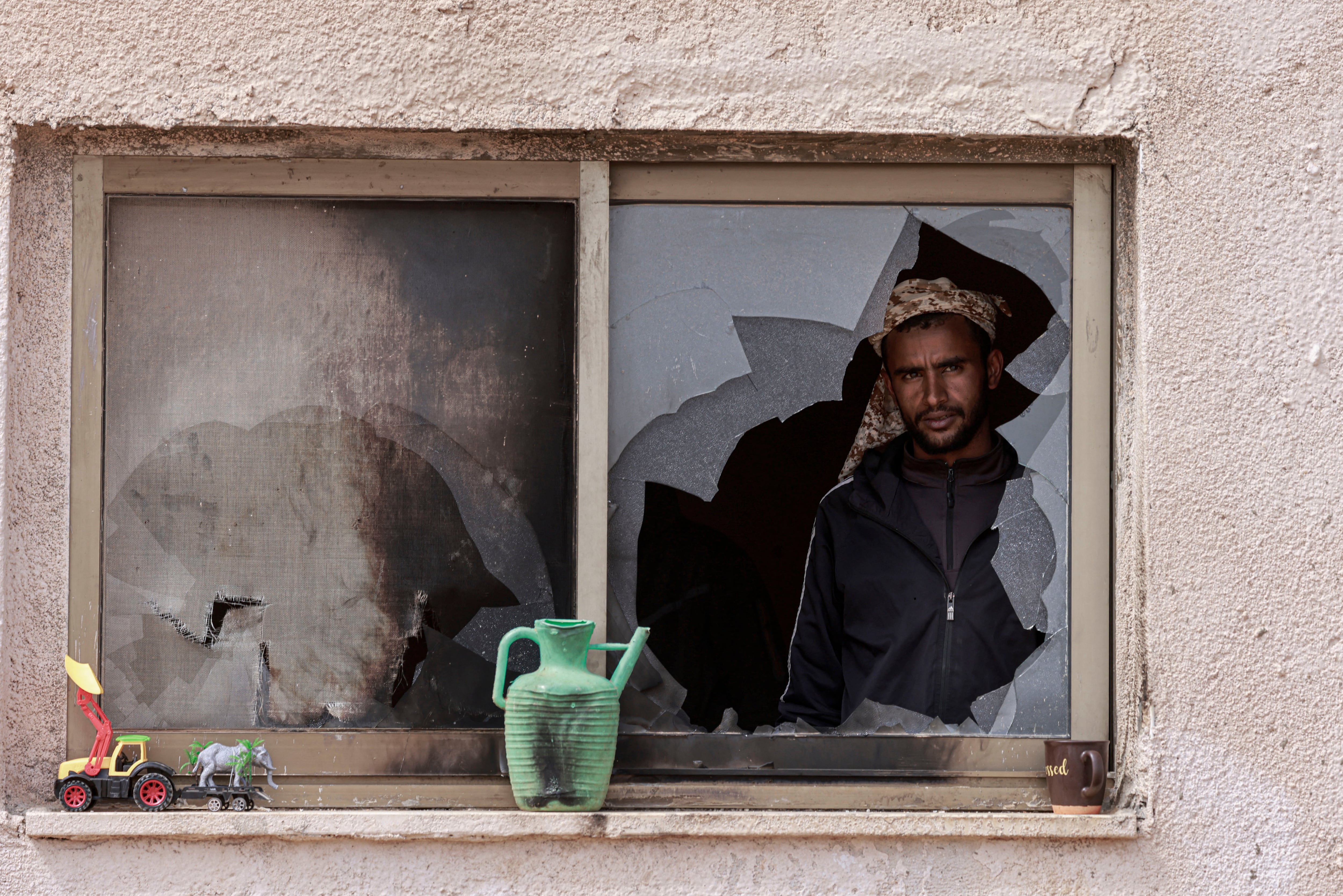 Un hombre palestino observa por la ventana de una casa destruida tras un ataque de colonos israelíes en las afueras de la aldea de Al-Lubban ash-Sharqiya, al sur de Nablus, en la Cisjordania ocupada, el 6 de abril de 2026.