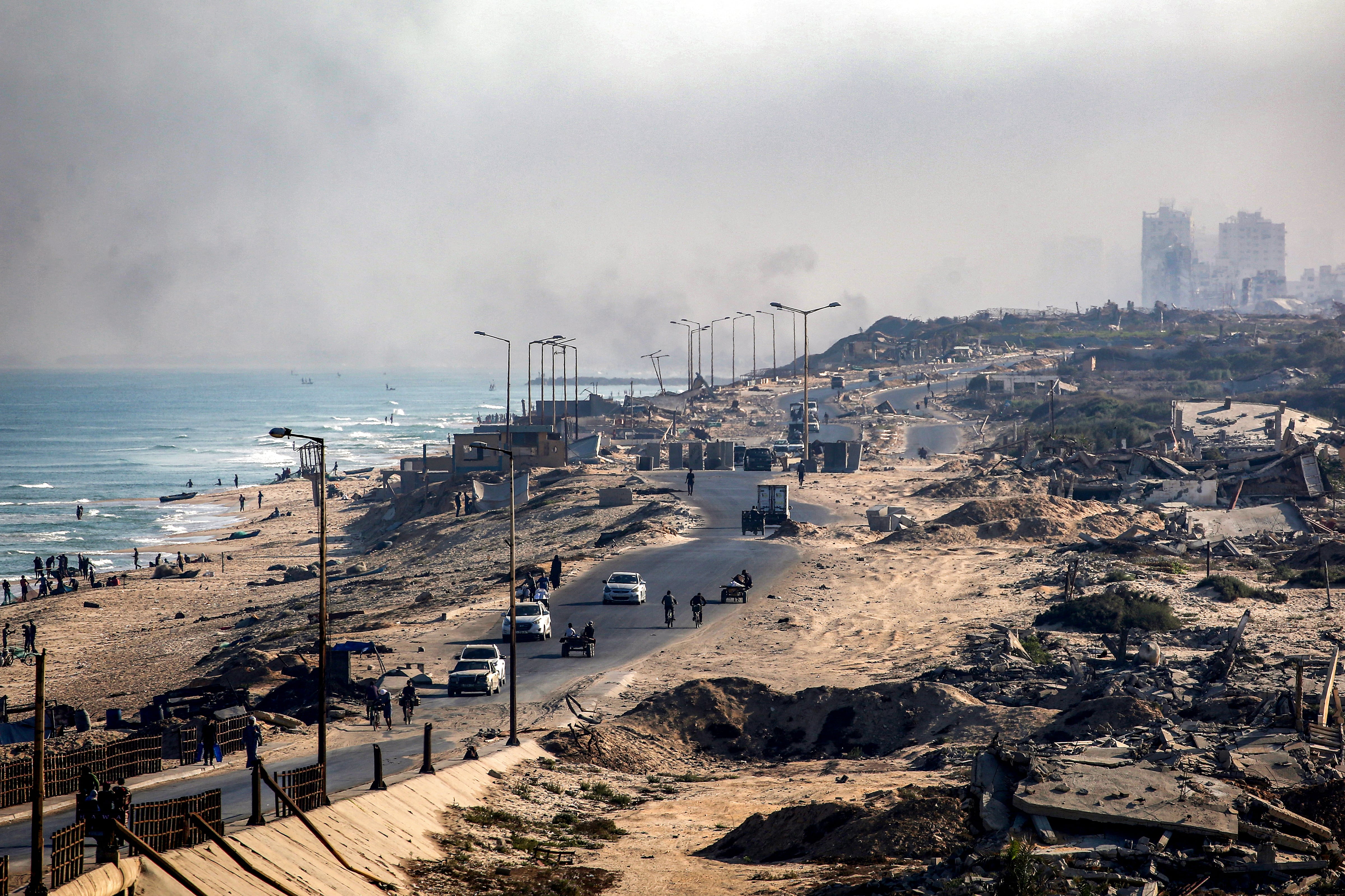 Vehículos junto a edificios destruidos a lo largo de la carretera costera que atraviesa el campamento de Nuseirat para refugiados palestinos, en el centro de la Franja de Gaza, este 30 de agosto. Fotografía: