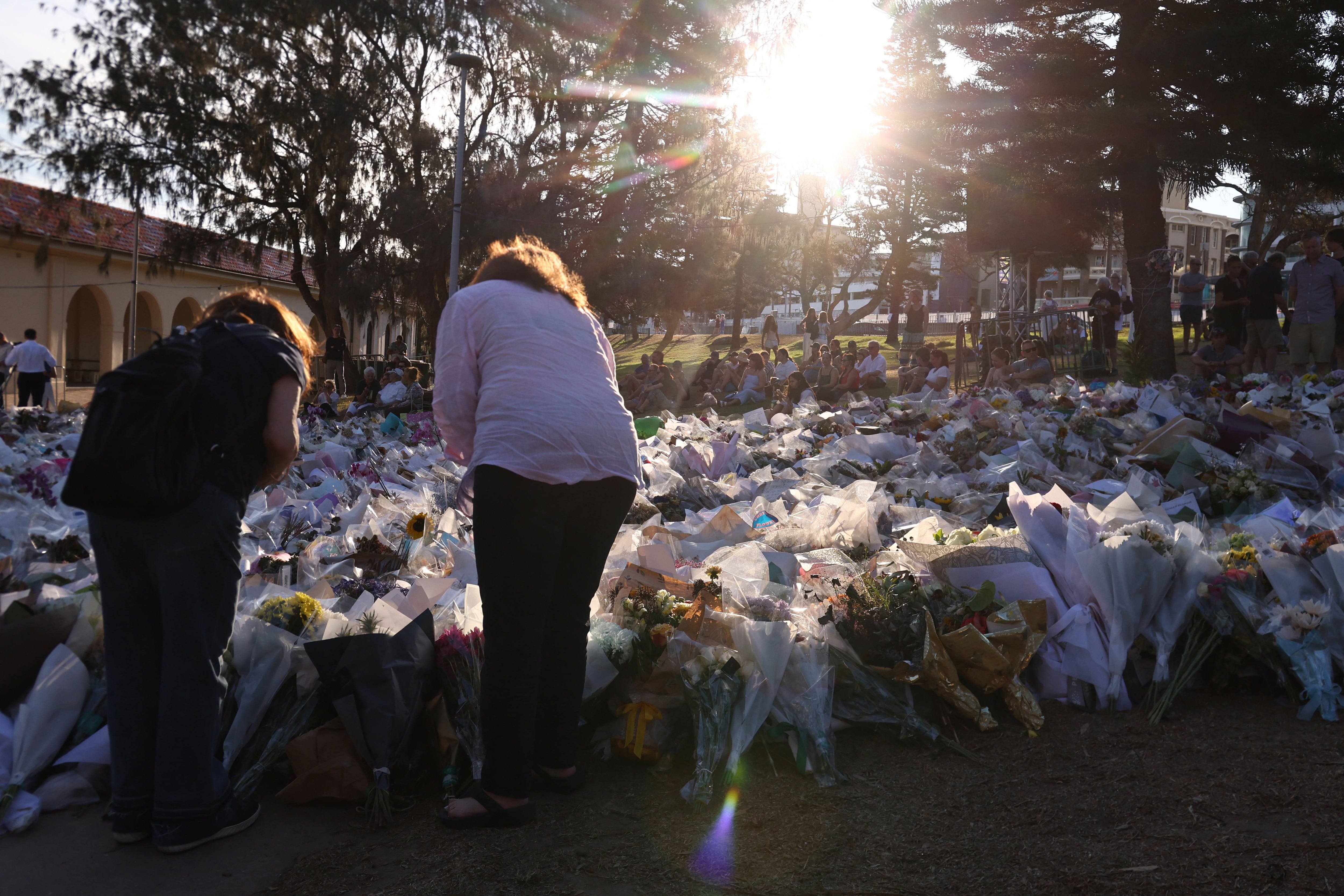 Dolientes se reúnen frente a los homenajes en memoria de las víctimas del tiroteo en Bondi Beach, Sídney, el 20 de diciembre de 2025. Padre e hijo armados están acusados de disparar contra la multitud en un festival judío en la playa el 14 de diciembre, matando a 15 personas en un ataque que las autoridades vincularon con la ideología del Estado Islámico.