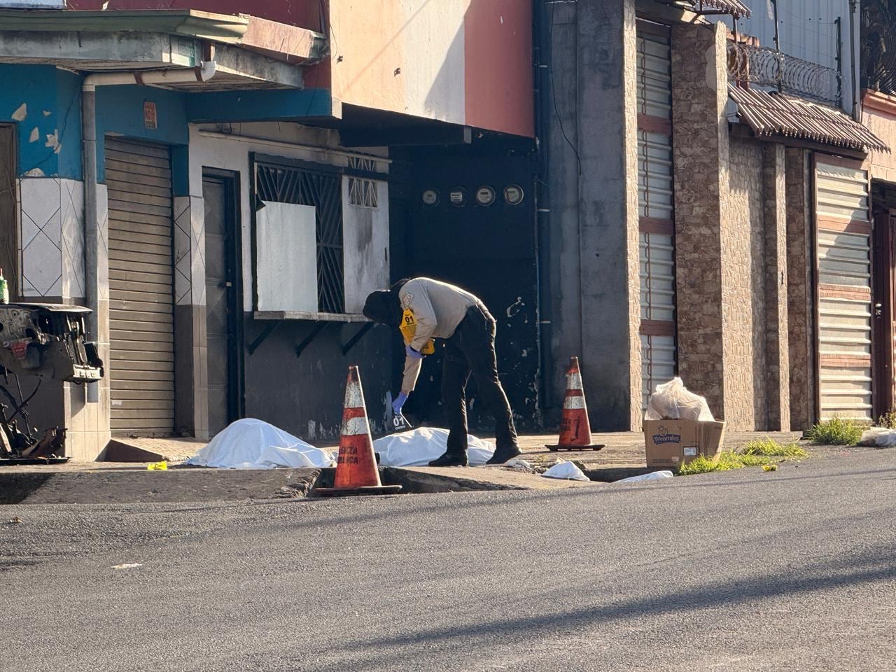 Agentes judiciales del OIJ inspeccionaron la escena en el sector de la plaza de deportes de Paso Ancho, donde tres hombres fueron declarados sin vida tras un ataque a balazos ocurrido la madrugada de este martes.