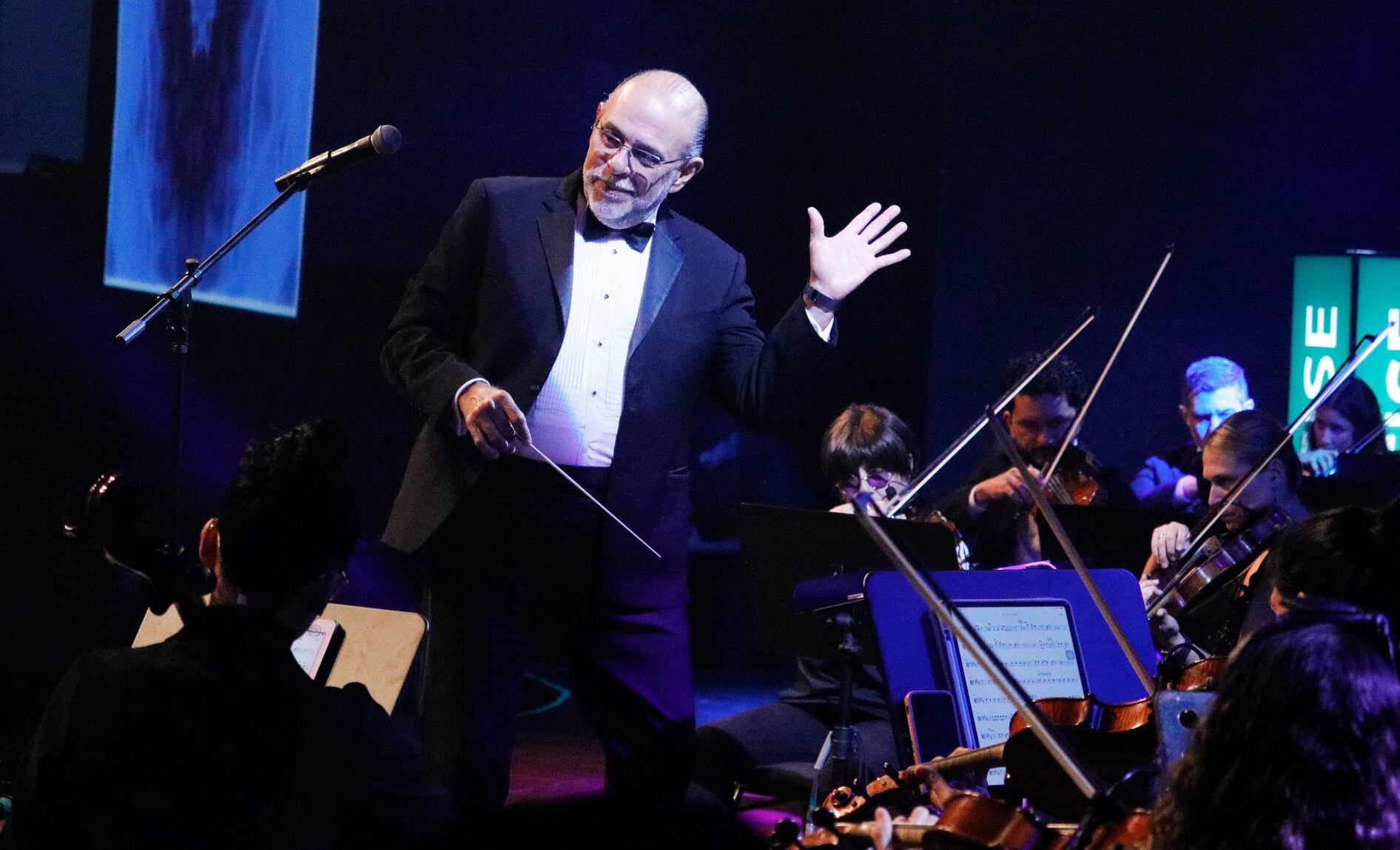 Foto de Marvin Araya, director de la Orquesta Filarmónica, en concierto. Usa traje negro y camisa blanca.
