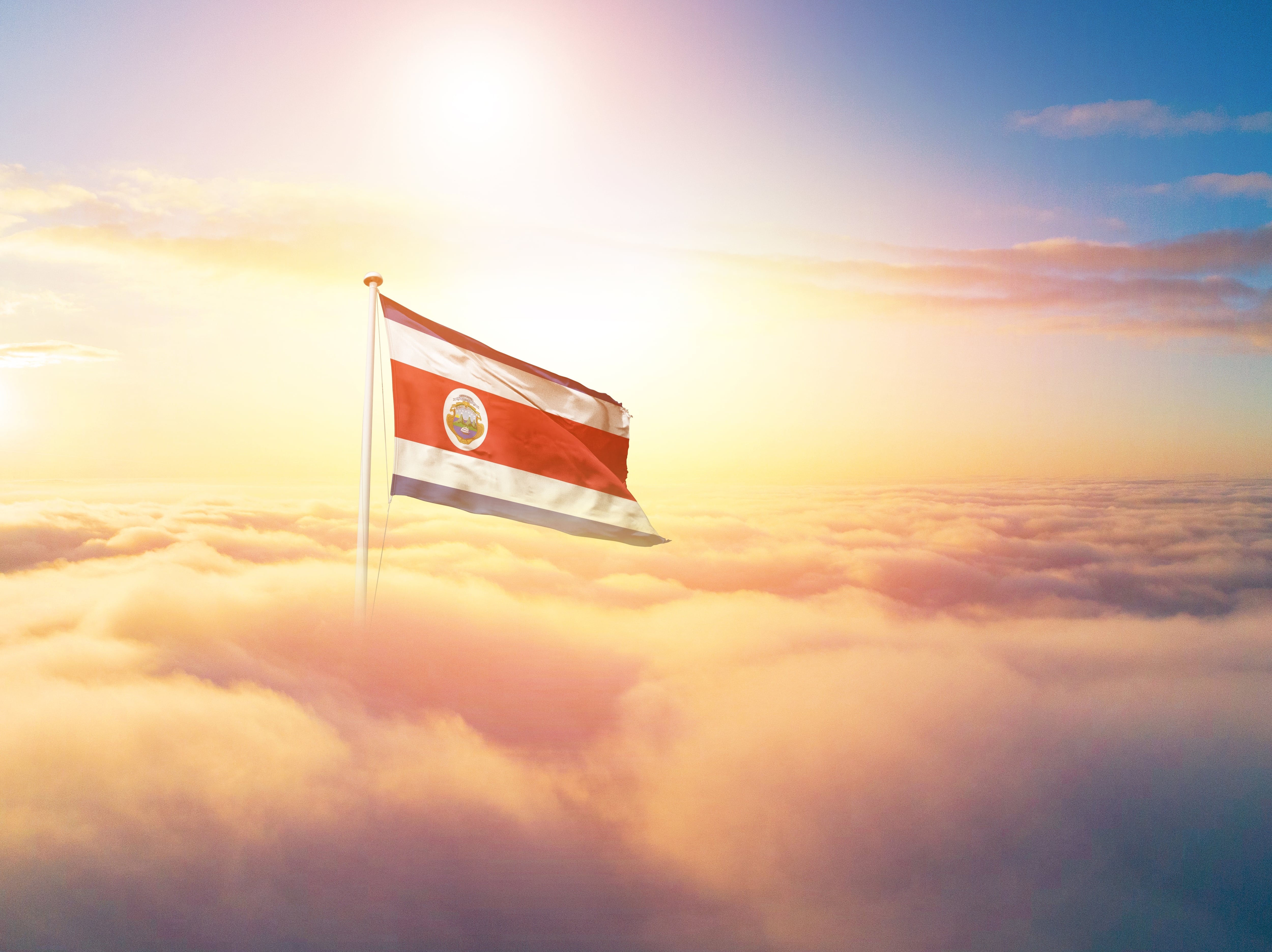 bandera de Costa Rica ondea entre nubes y cielo