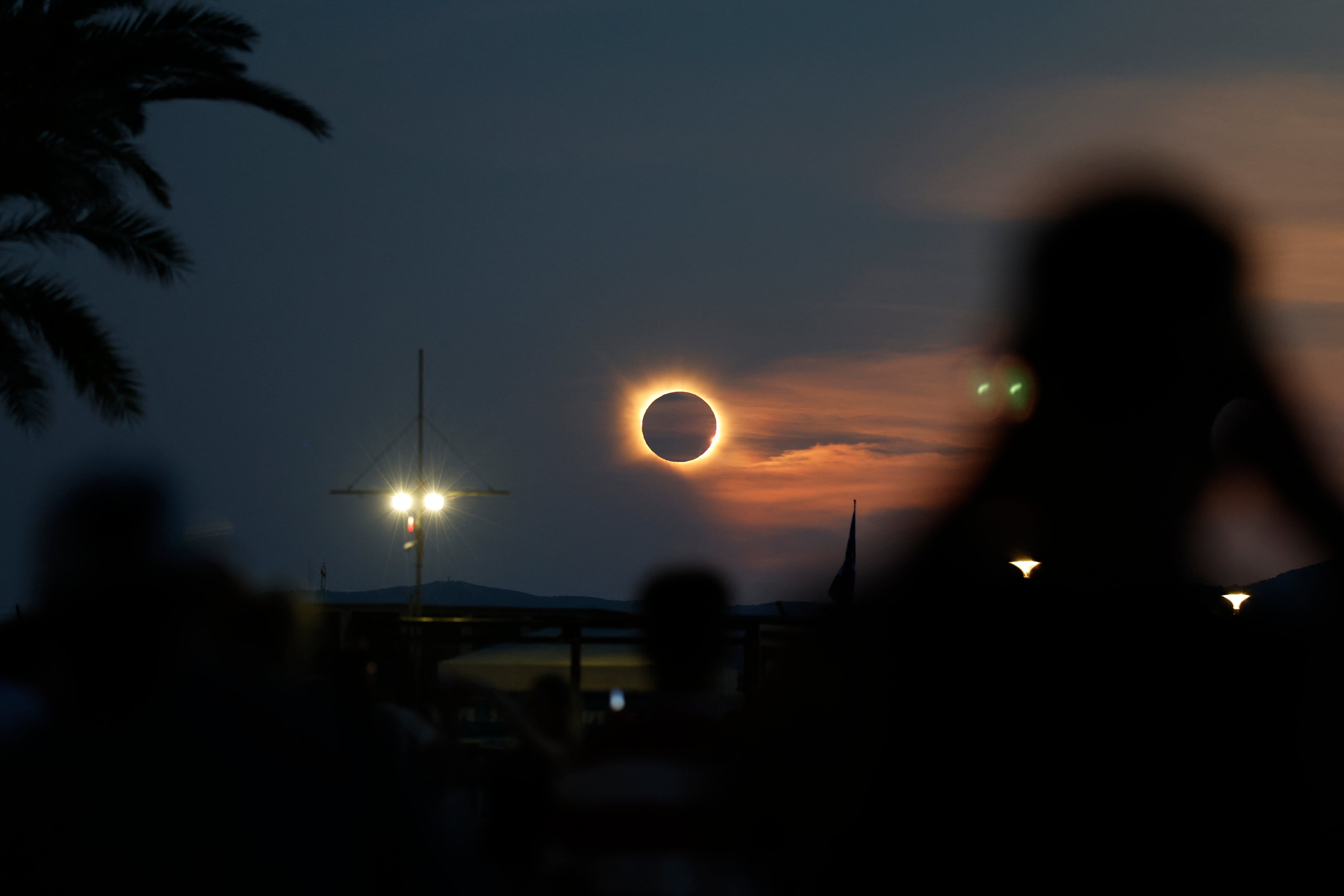 La corona solar brilla mientras la Luna bloquea por completo al Sol durante la fase de totalidad del eclipse solar total, tal como se observa desde la playa de Arenal en Llucmajor, en la isla balear de Mallorca, el 12 de agosto de 2026. Millones de europeos contemplaron hoy el cielo con asombro durante un raro eclipse solar total que sumirá a una franja de España en una inquietante oscuridad diurna. La sombra proyectada cuando la Luna cubre al Sol comenzó en el remoto norte ártico de Rusia alrededor de las 17:00 GMT y continuó en un arco a través de Groenlandia e Islandia. España fue el lugar donde la mayoría de la gente observó el eclipse total, que atravesó el país en diagonal desde la costa atlántica del norte hasta el mar Mediterráneo, donde desapareció alrededor de las 18:30 GMT. (Foto de Jaime REINA / AFP)