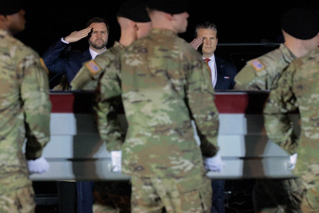 El vicepresidente de Estados Unidos, JD Vance, y el secretario de Guerra, Pete Hegseth, saludan mientras un equipo del Ejército estadounidense traslada un féretro cubierto con la bandera que contiene los restos del sargento Benjamin N. Pennington en la Dover Air Force Base, el 9 de marzo de 2026, en Dover, Delaware.