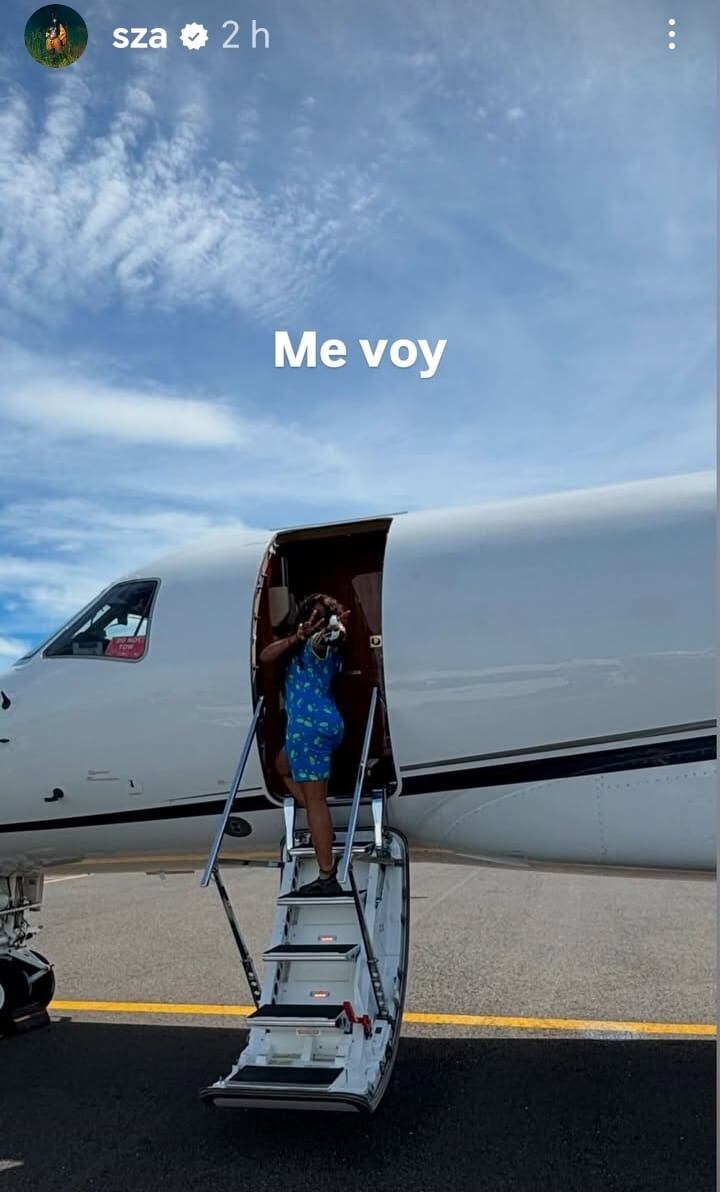 Imagen de la cantante SZA subiendo a un avión despidiéndose de Costa Rica. La artista lleva un vestido de color azul.