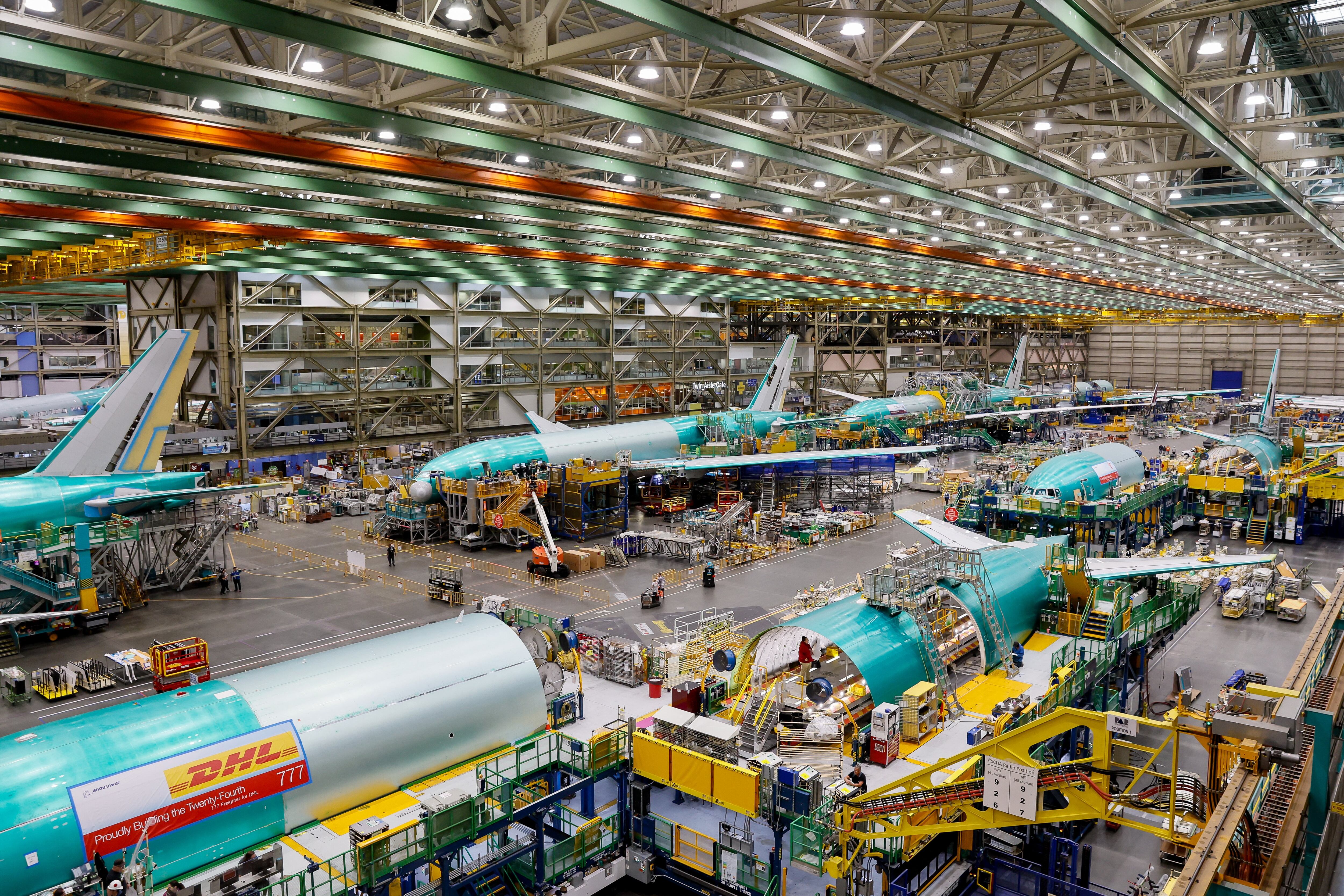 (FILES) This general view shows Boeing 777 freighters and 777X as they are assembled at the Everett Production Facility in Everett, Washington on June 26, 2024. Boeing on October 28, 2024, announced a stock offering expected to raise up to USD19 billion, saying proceeds will go towards repaying debt and investing in its subsidiaries. The aviation giant, which last week reported a whopping $6.2 billion quarterly loss, has been suffering from a strike by some 33,000 US workers that has paralyzed two major plants since mid-September. (Photo by Jennifer Buchanan / POOL / AFP)