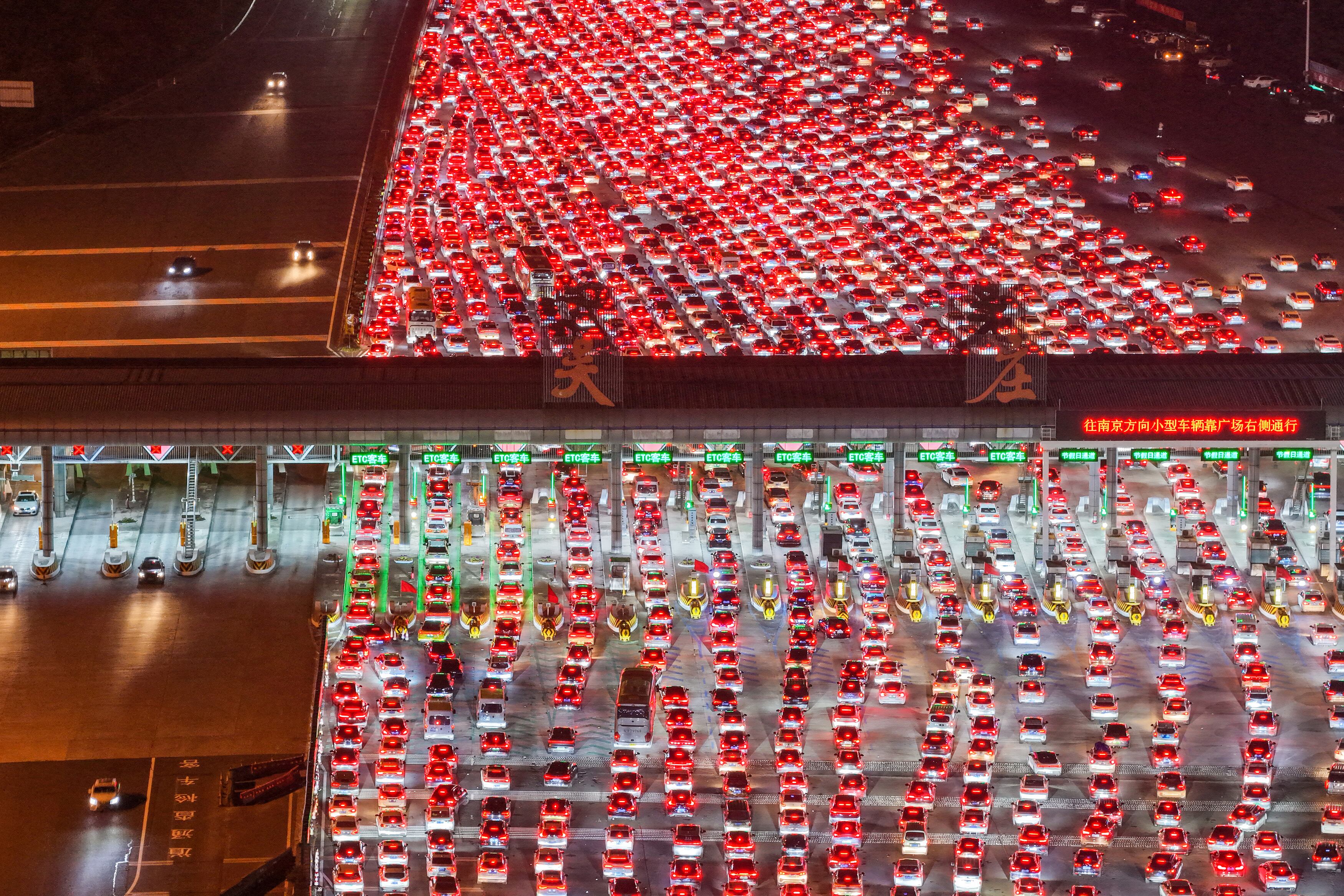 Conductores esperan para pasar por la estación de peaje de Wuzhuang, en una autopista en Chuzhou, en la provincia oriental de Anhui, China, mientras regresaban a casa en el penúltimo día del feriado de ocho días por el Día Nacional, el 7 de octubre de 2025. La estación de peaje de Wuzhuang, ubicada en la frontera entre las provincias de Anhui y Jiangsu, es la más grande de China en autopistas, con un total de 36 carriles. (Foto: AFP) / Prohibida su distribución en China.