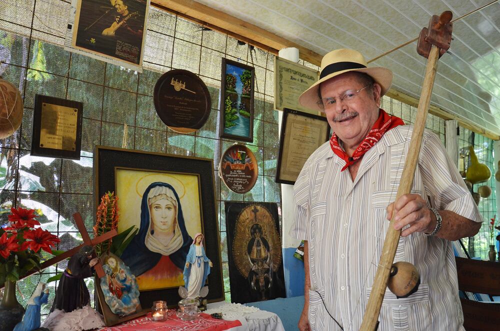Imagen del folclorista costarricense Lorenzo Lencho Salazar sosteniendo un quijongo, vestido con camisa blanca, pañuelo rojo y sombrero.