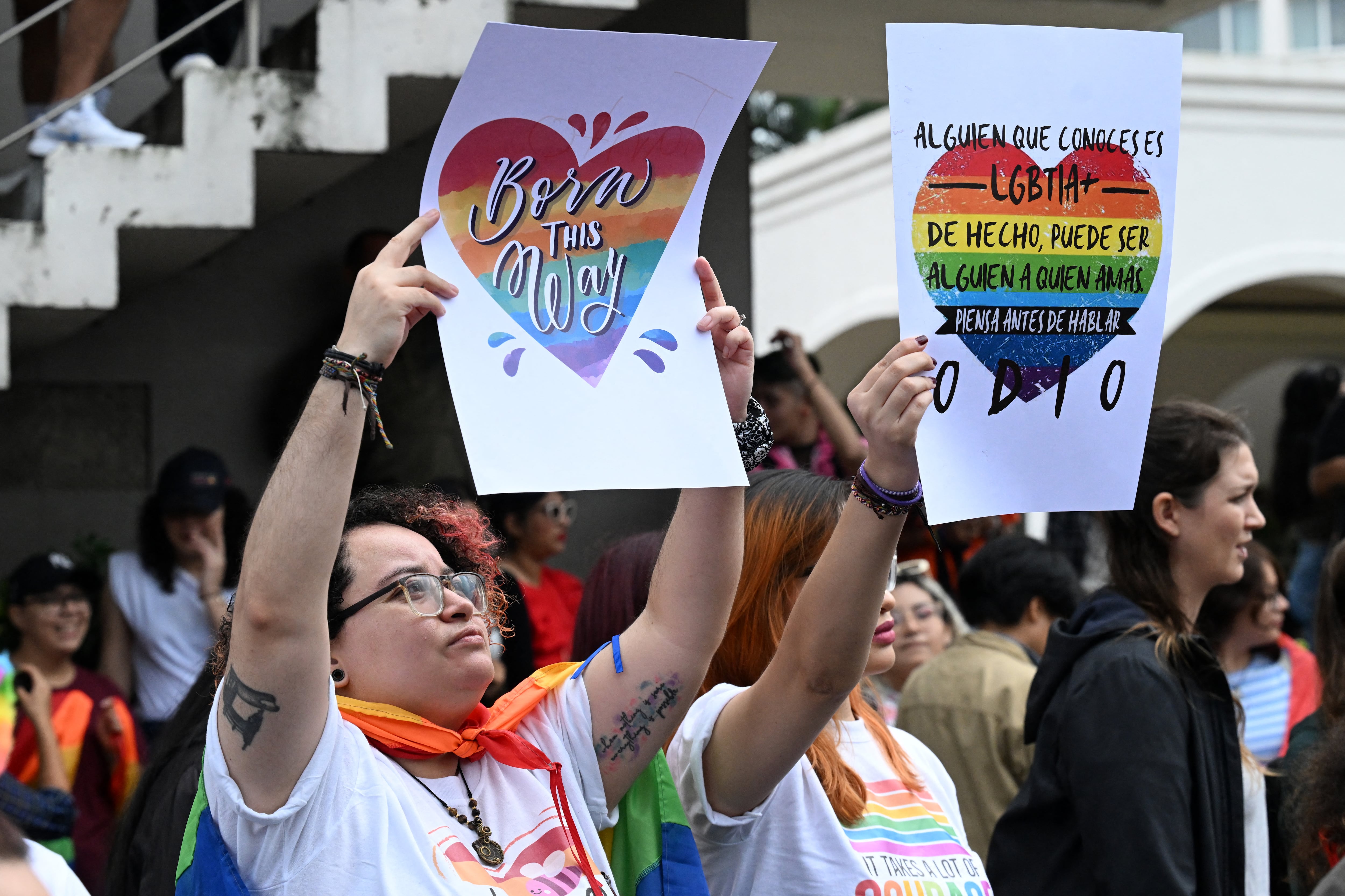 Fiorella Turchkeim (izq.) y Andrea Ordóñez sostienen carteles que abogan por los derechos LGBT en la Marcha del Orgullo en San Salvador el 29 de junio de 2024. Foto: Marvin RECINOS / AFP