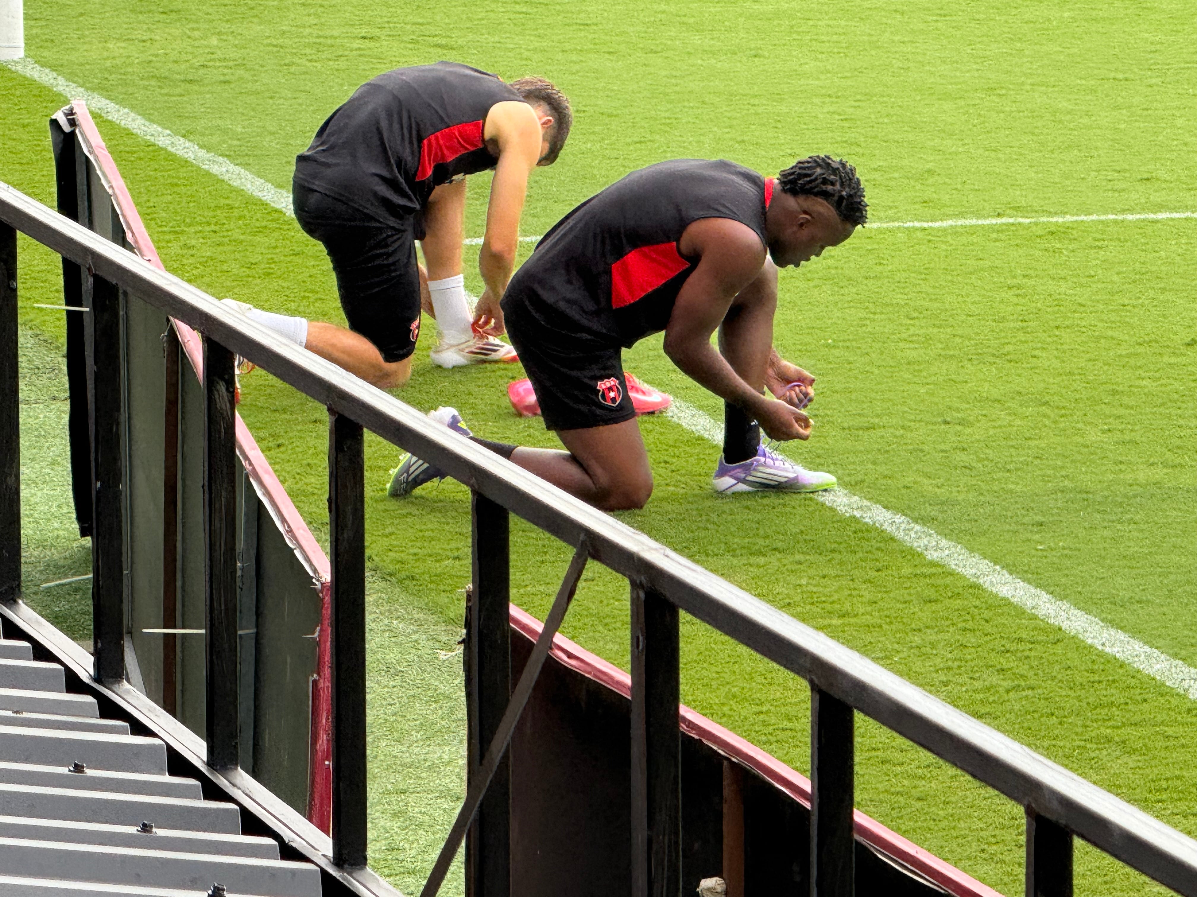 Elián Quesada y Joel Campbell se amarran sus zapatillas antes de la práctica previa al partido entre Liga Deportiva Alajuelense y Plaza Amador, en la Copa Centroamericana de Concacaf.