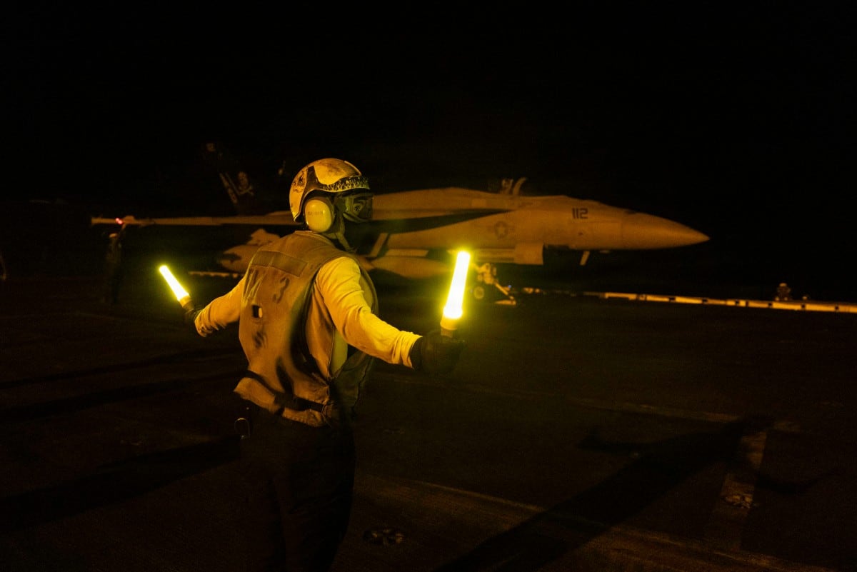 Esta fotografía proporcionada por la Marina de Estados Unidos y difundida el 28 de julio de 2026 por la oficina de asuntos públicos del Comando Central de Estados Unidos muestra a un marinero estadounidense dando señales a un caza F/A-18E Super Hornet sobre la cubierta de vuelo del portaaviones de la clase Nimitz USS George H.W. Bush, el 21 de julio de 2026.