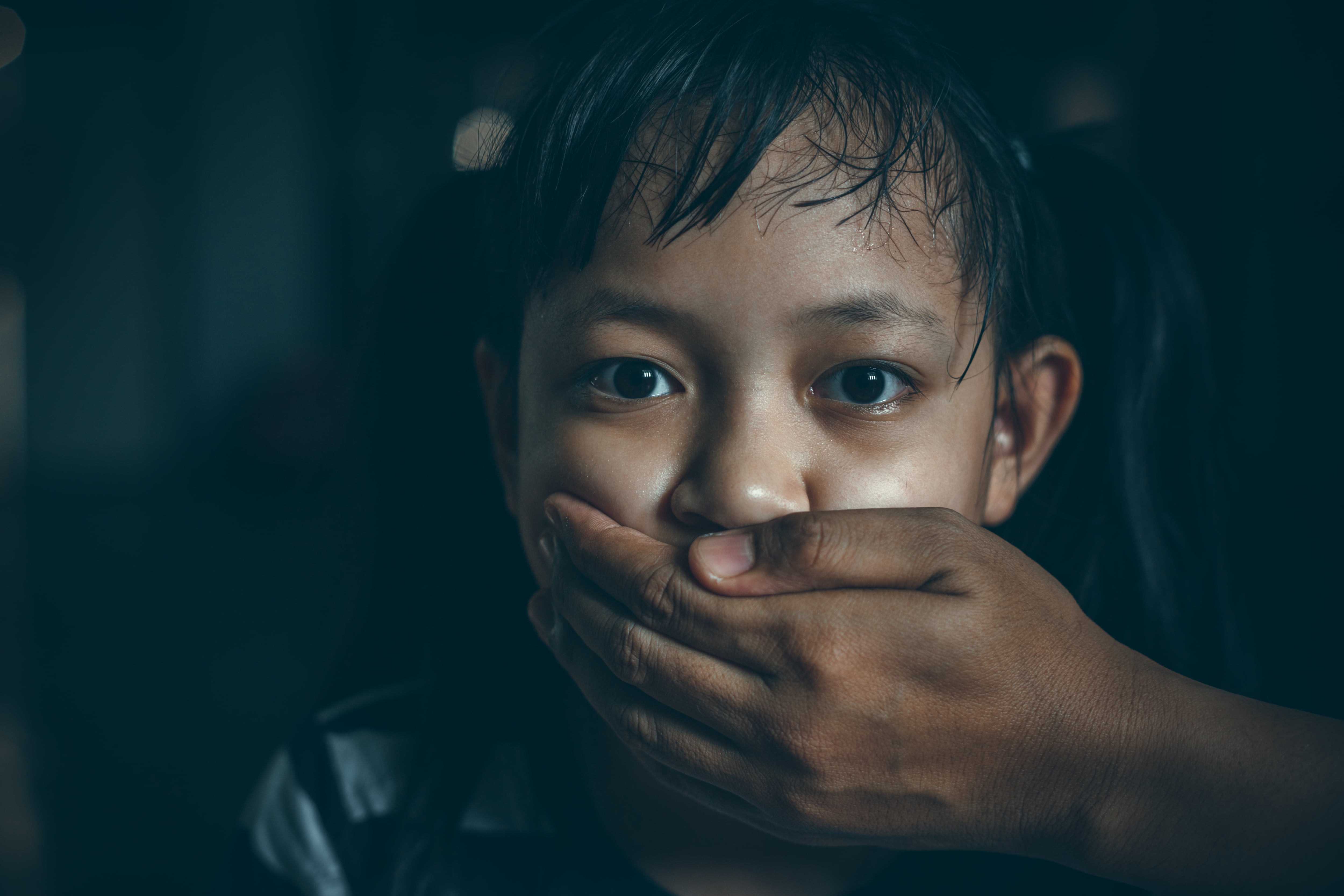 Niño con la boca cubierta, mano adulta tapa la boca de niño, niña, silencio impuesto, libertad de expresión, niñez y expresión pública de ideas