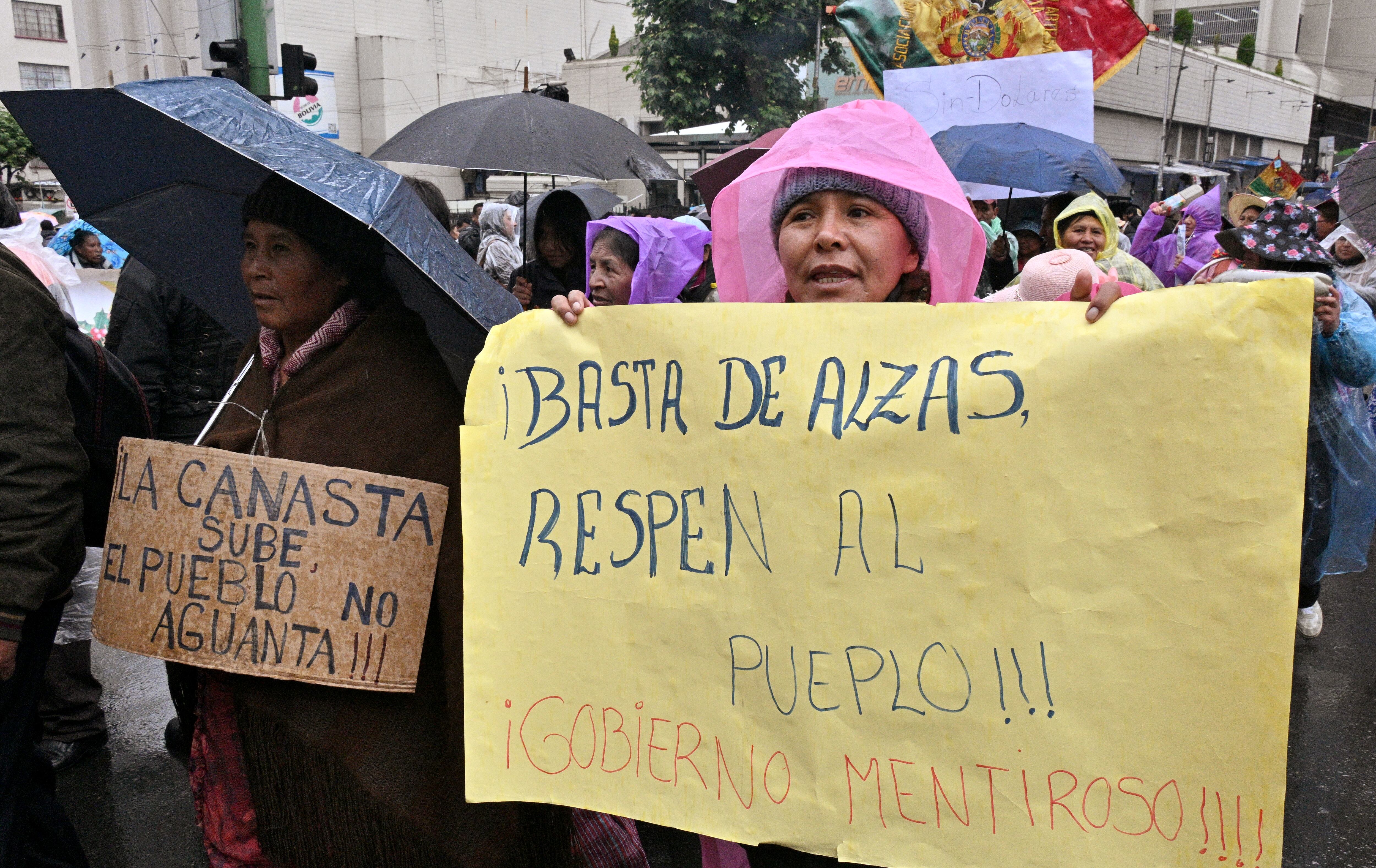 Manifestantes en La Paz, Bolivia, el 21 de noviembre de 2024, protestan contra la escasez de dólares y combustible, expresando descontento por los aumentos de precios. La incertidumbre económica, alimentada por las tensiones entre Evo Morales y Luis Arce, ha provocado una ola de desconfianza hacia las autoridades. Foto: Aizar Raldes / AFP
