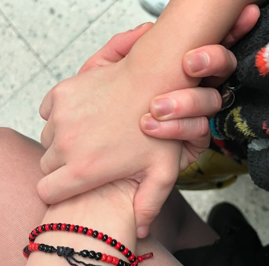 Fotografía de la mano de Imelda Garza entrelazada con la de su hijo, José Julián.