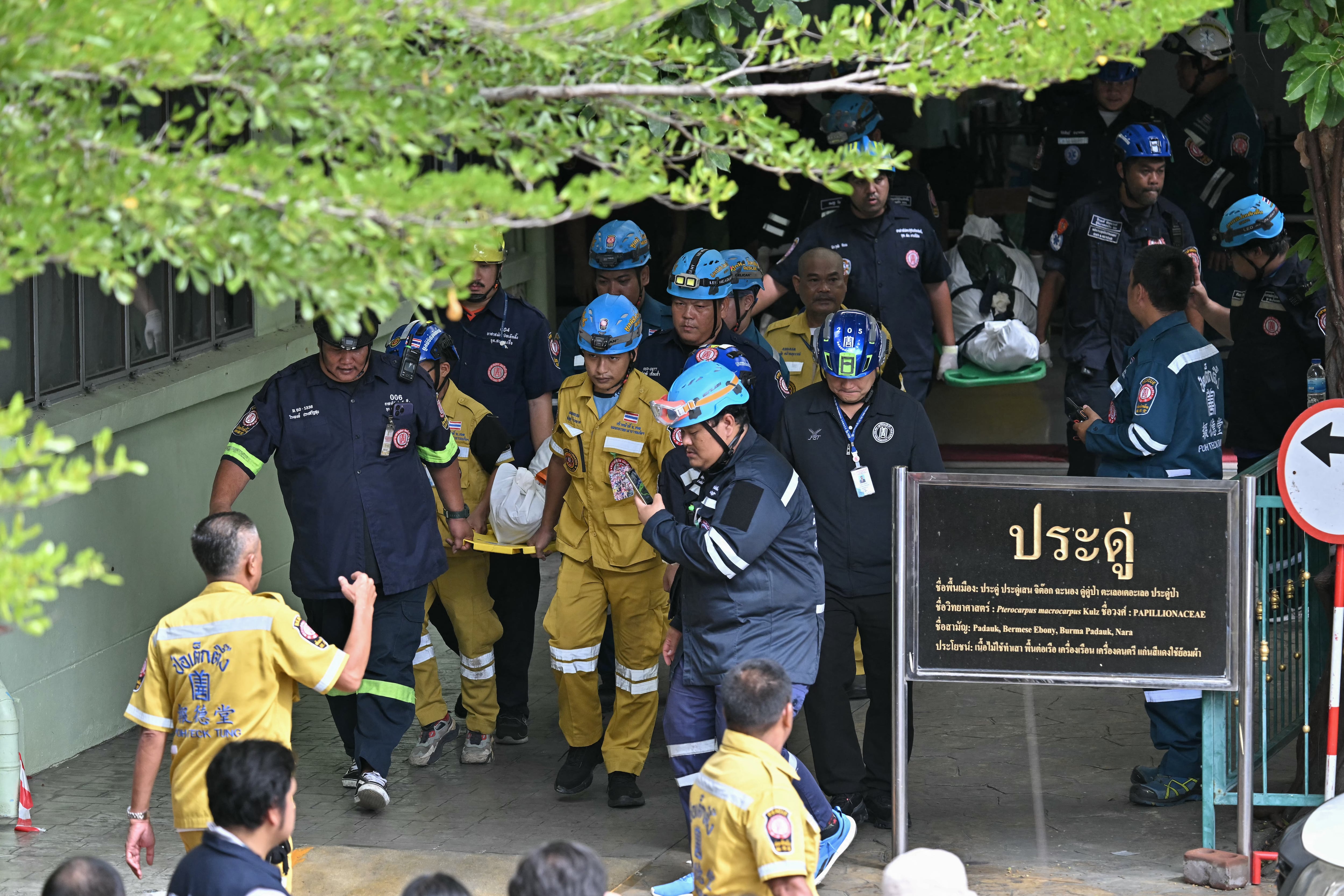 The bodies of school shooting victims are carried out of the school premises in Bang Kruai district, Nonthaburi province, north of the Thai capital Bangkok, on August 7, 2026. A teenager described as "troubled" by a classmate killed his grandparents before gunning down at least six more people at a school in Thailand on August 7, police said. (Photo by Lillian SUWANRUMPHA / AFP)