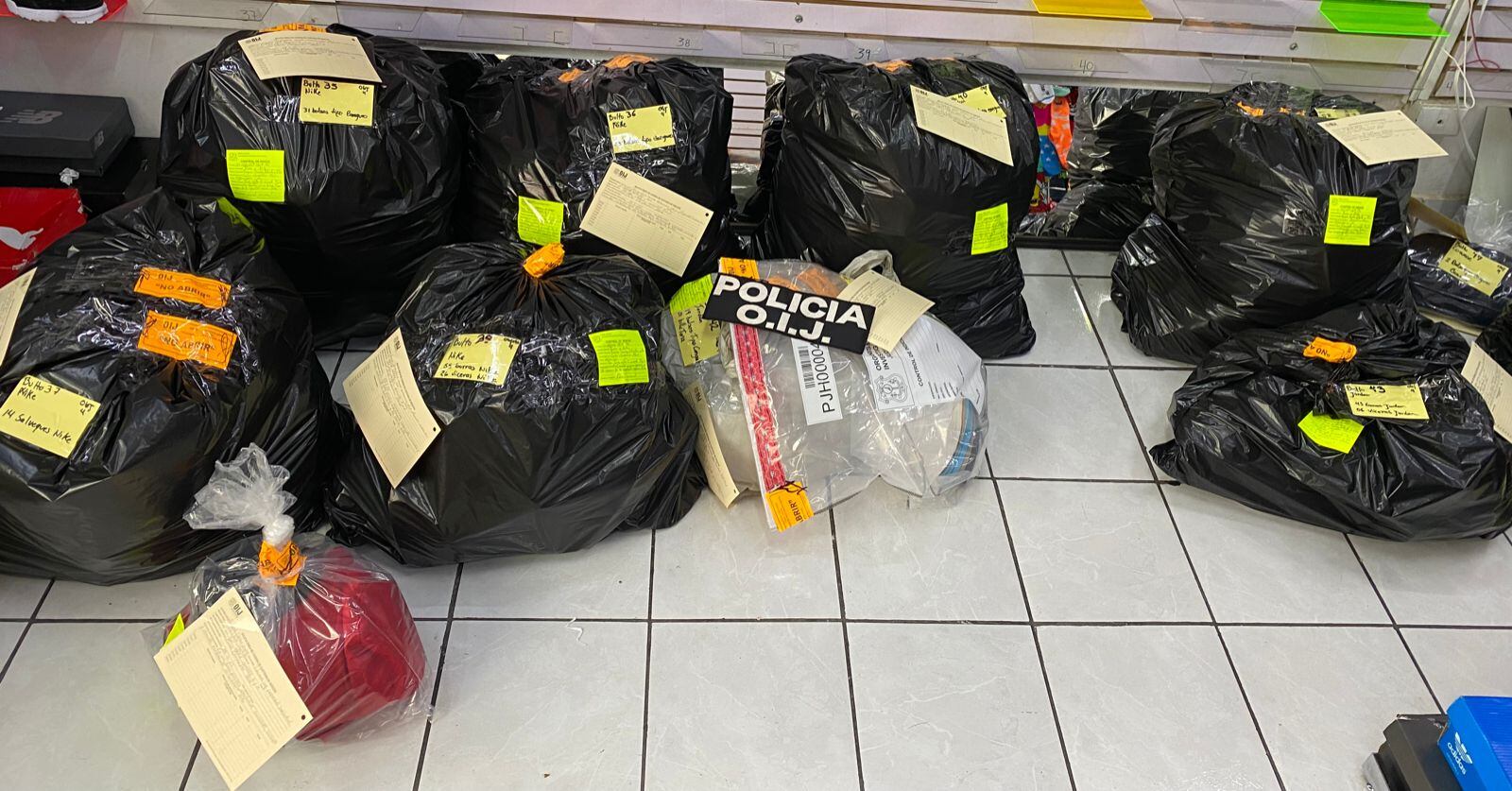 Ropa, zapatos, salveques y gorras, son parte de lo decomisado en cinco allanamientos del OIJ a locales en las cercanías del barrio chino de San José. Foto: Cortesía OIJ.