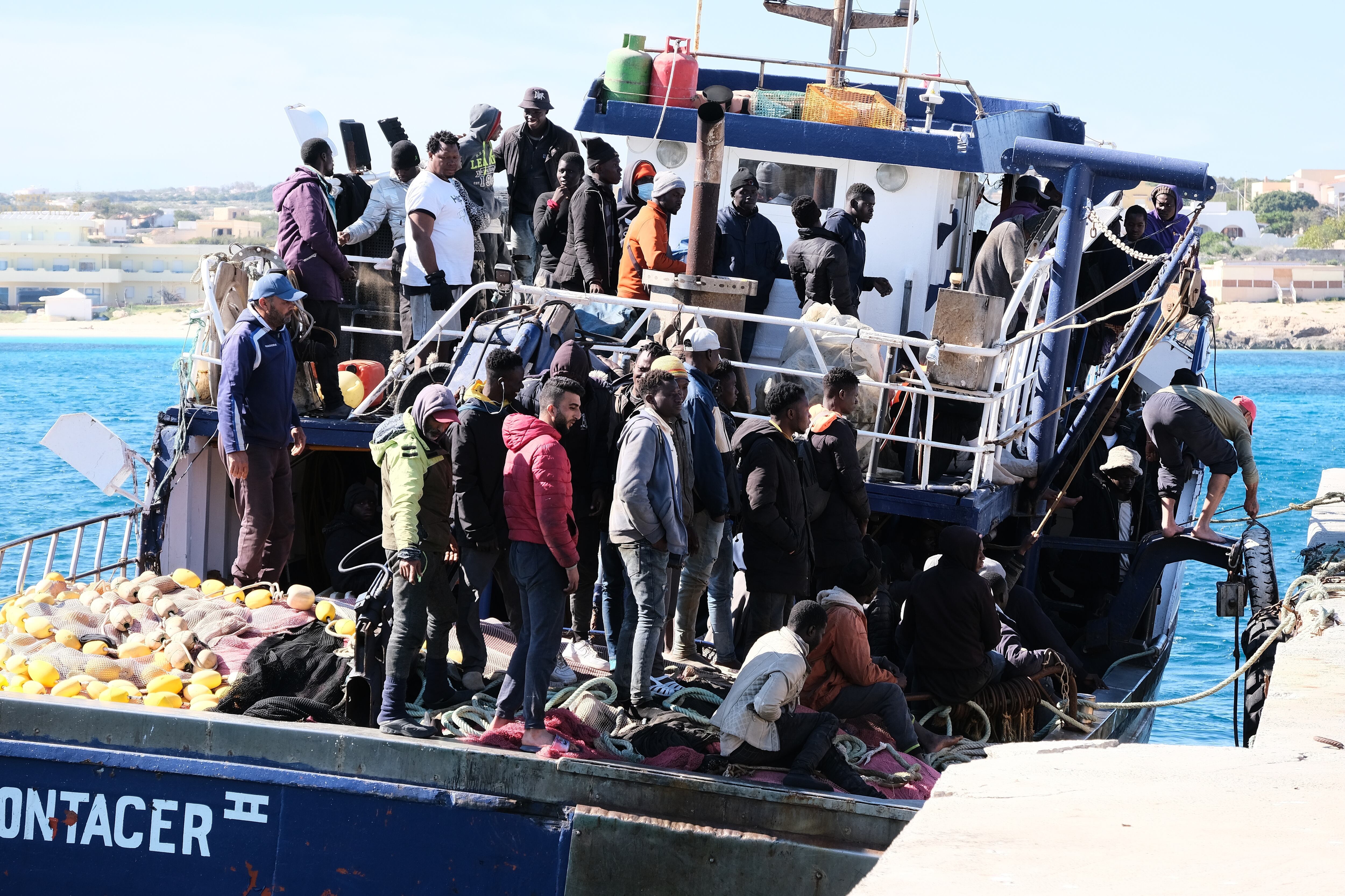 Barco con migrantes africanos en su arribo a Lampeduda, Italia