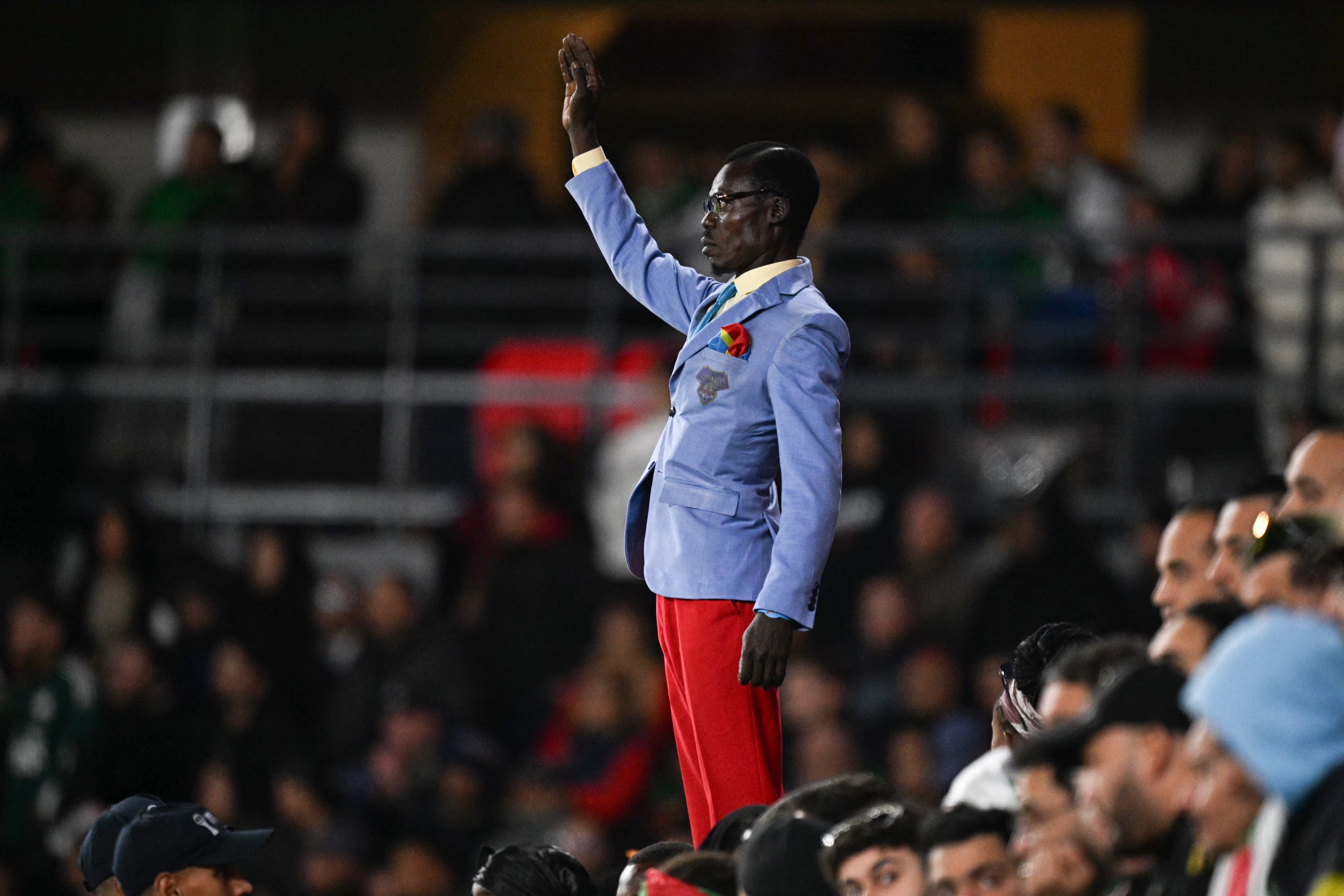 Michel Kuka Mboladinga, simpatizante de la República Democrática del Congo, rinde homenaje al fallecido primer ministro de la República Democrática del Congo, Patrice Lumumba, permaneciendo inmóvil antes del partido de octavos de final de la Copa Africana de Naciones (CAN) entre Argelia y la República Democrática del Congo en el estadio Príncipe Moulay El Hassan de Rabat, el 6 de enero de 2026.