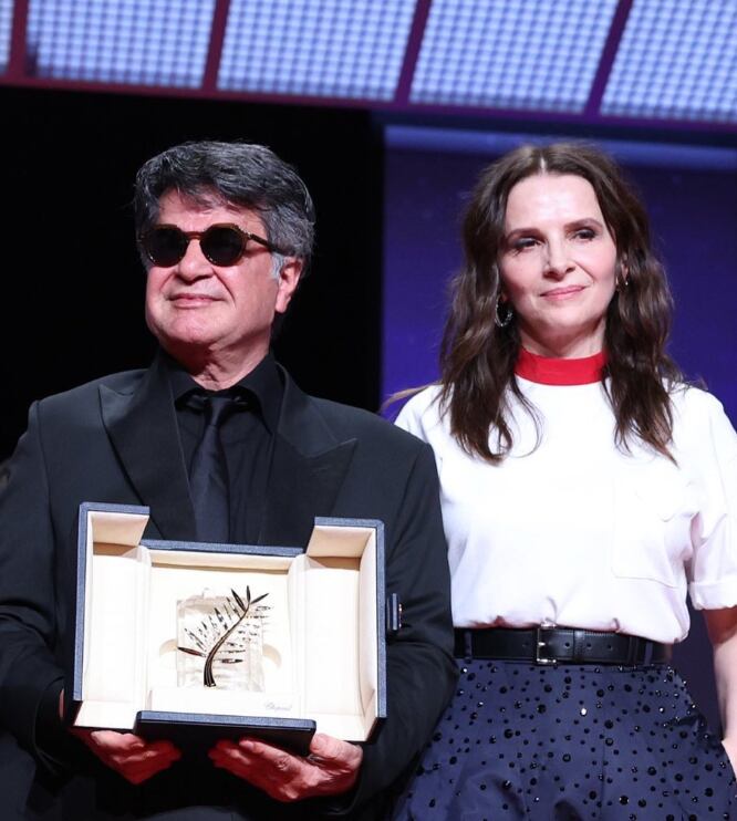 Jafar Panahi con la Palma de Oro, al lado de Juliette Binoche, presidenta del jurado en Cannes 2025.