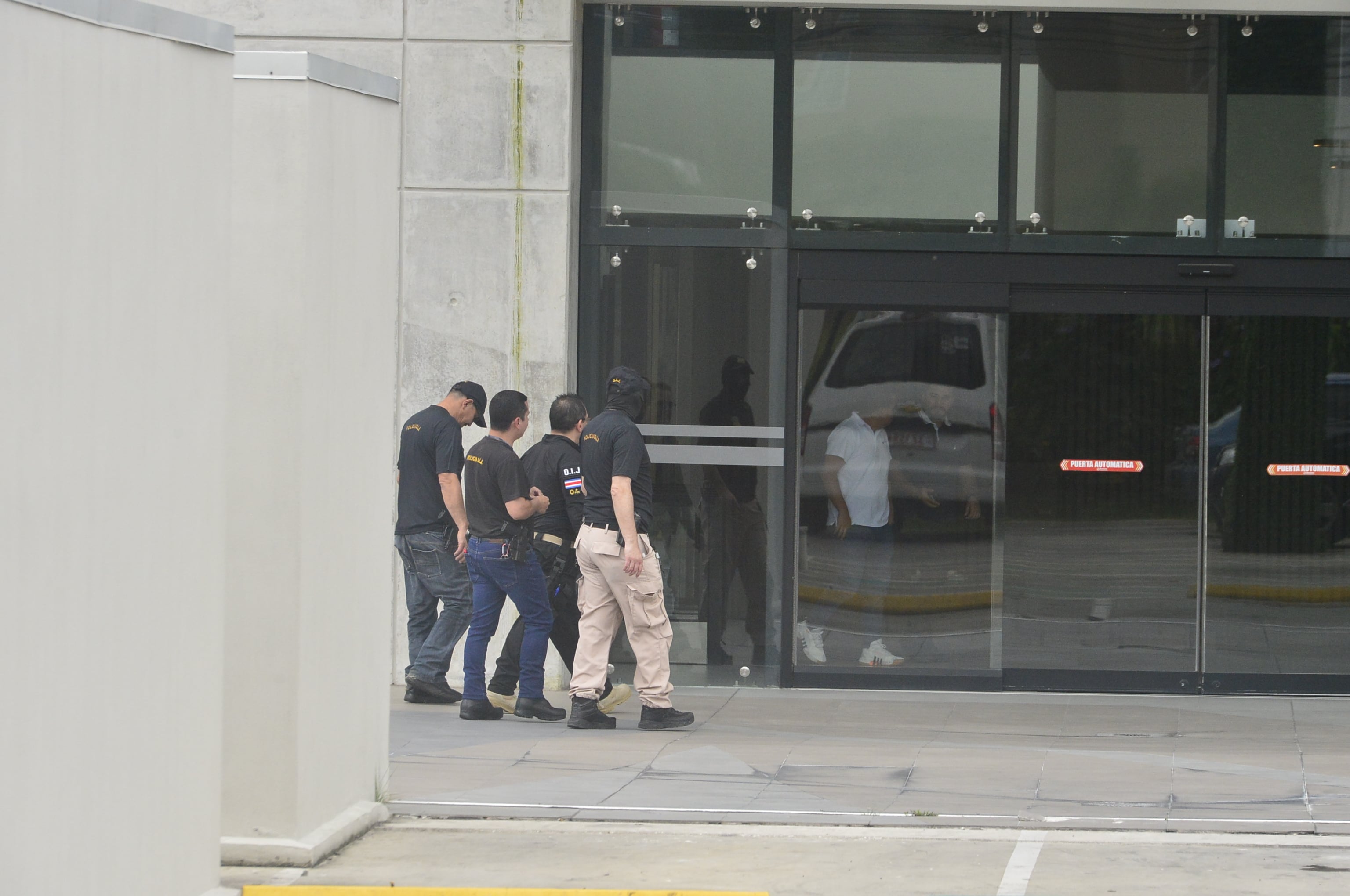 Agentes del OIJ ingresan a un edificio durante un allanamiento relacionado con el caso de la Financiera Desyfin en Costa Rica.