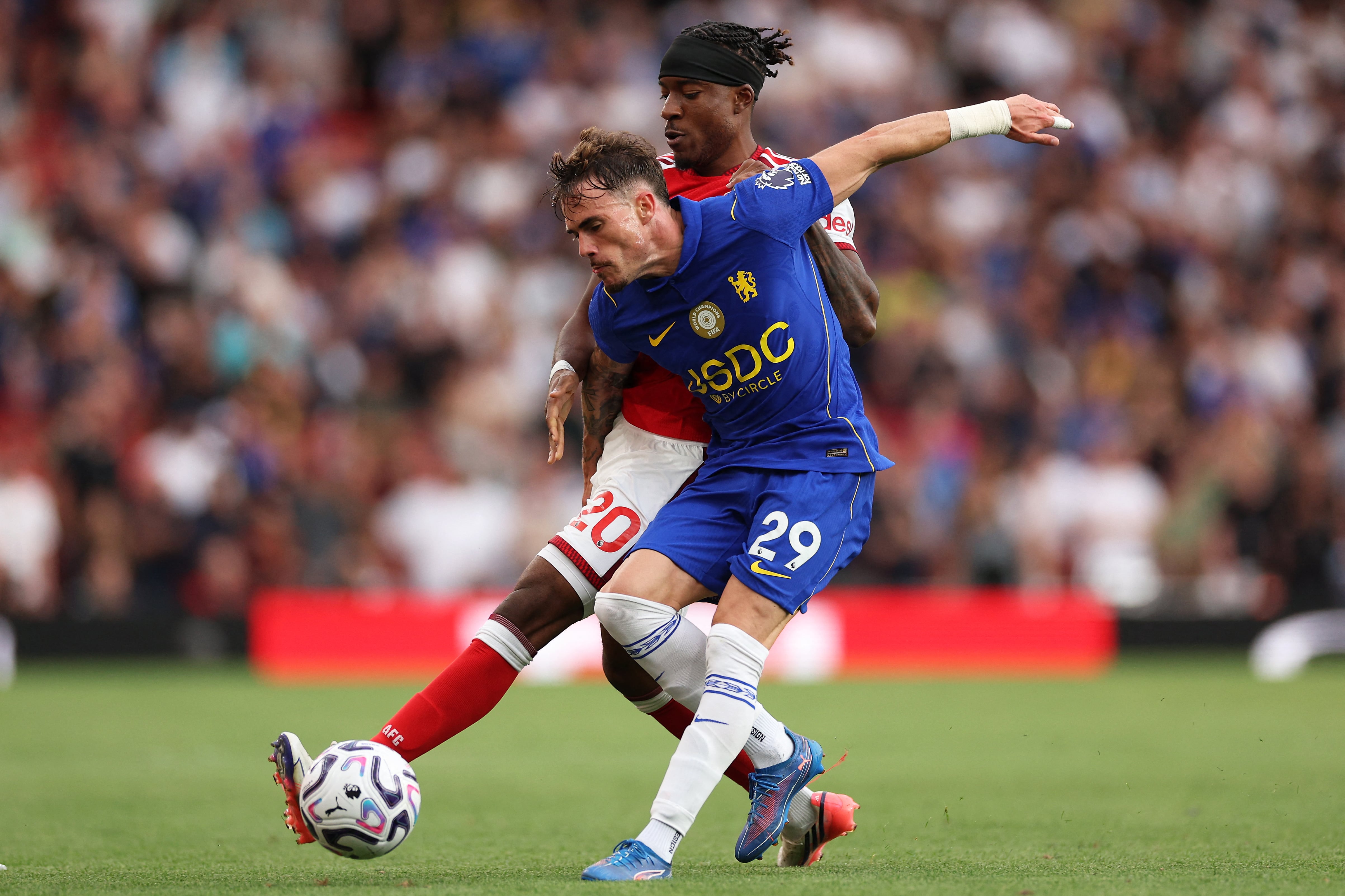 Noni Madueke, del Arsenal (20) disputa el balón con Pep Chavarría, del Chelsea, en este compromiso de la Premier League disputado en el Emirates Stadium de Londres.