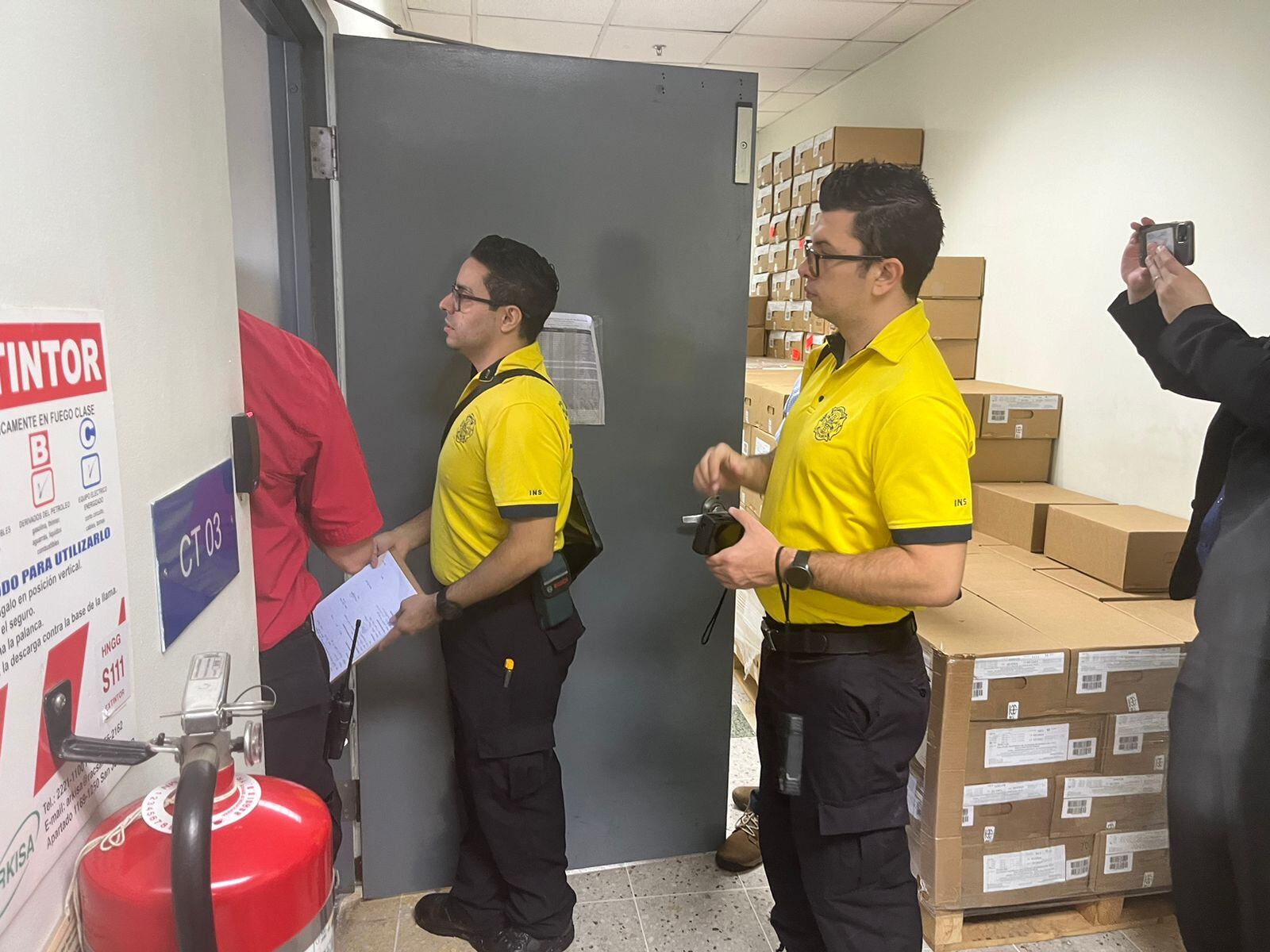Cuatro personas, dos con camiseta del Cuerpo de Bomberos, toman nota durante la inspección.