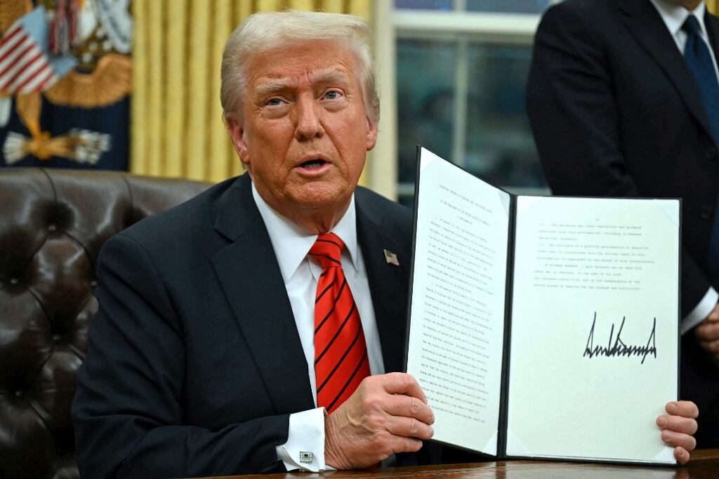 Donald Trump, expresidente de Estados Unidos, en la Oficina Oval sosteniendo un documento firmado, en el contexto de su estrategia de presión comercial a Canadá, México y China.