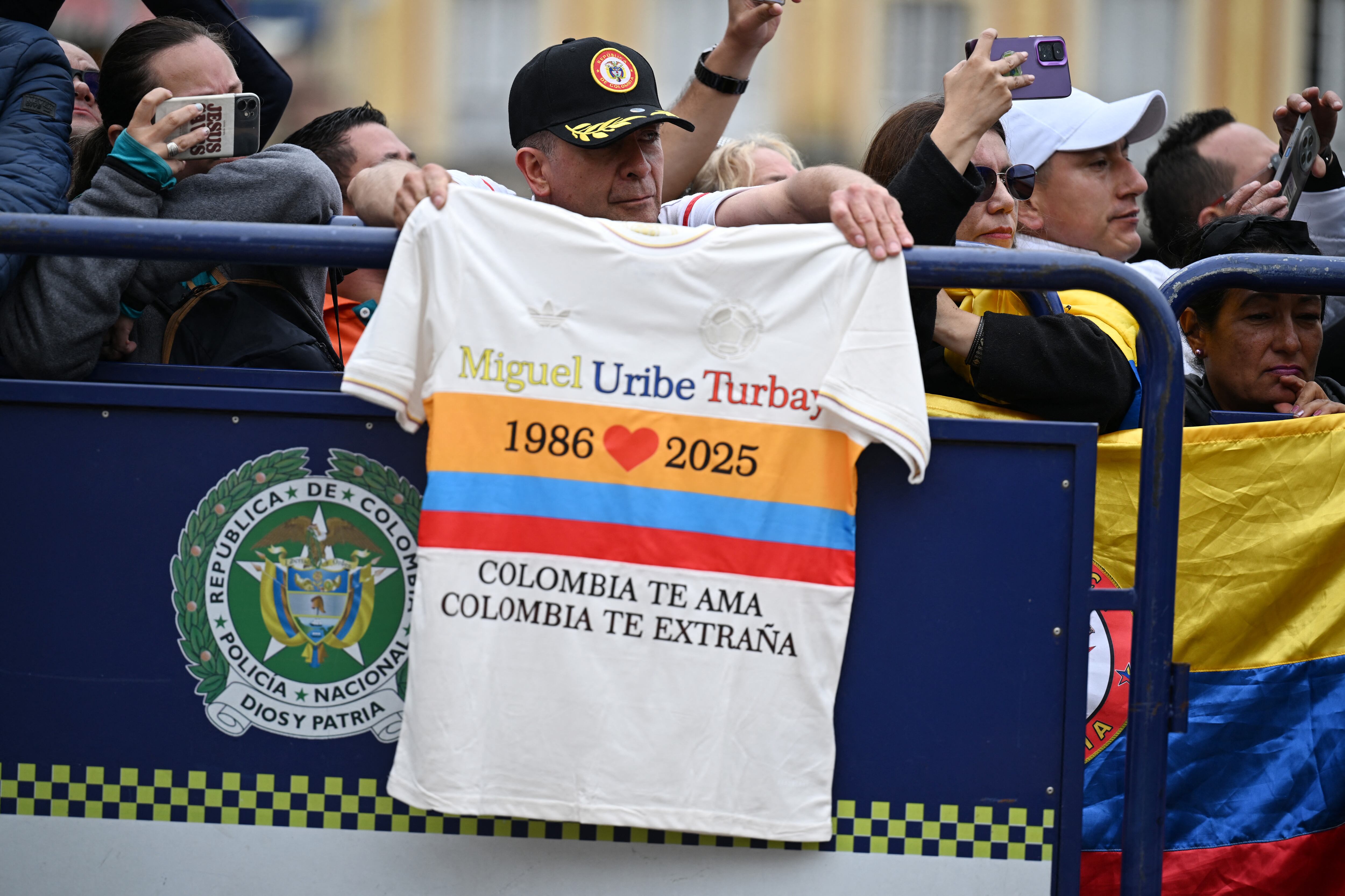 Miguel Uribe Londono (R), father of slain Colombian presidential candidate Miguel Uribe, touches the coffin of his son as his daughter-in-law, widow Mar�a Claudia Tarazona (L), among other relatives, mourns during the burial at the Central Cemetery in Bogota on August 13, 2025. Colombian presidential candidate Miguel Uribe died two months after being shot in the head at a campaign event, his wife announced early August 11, 2025, as the attack rekindled fears of a return to the nation's violent past. (Photo by RAUL ARBOLEDA / AFP)