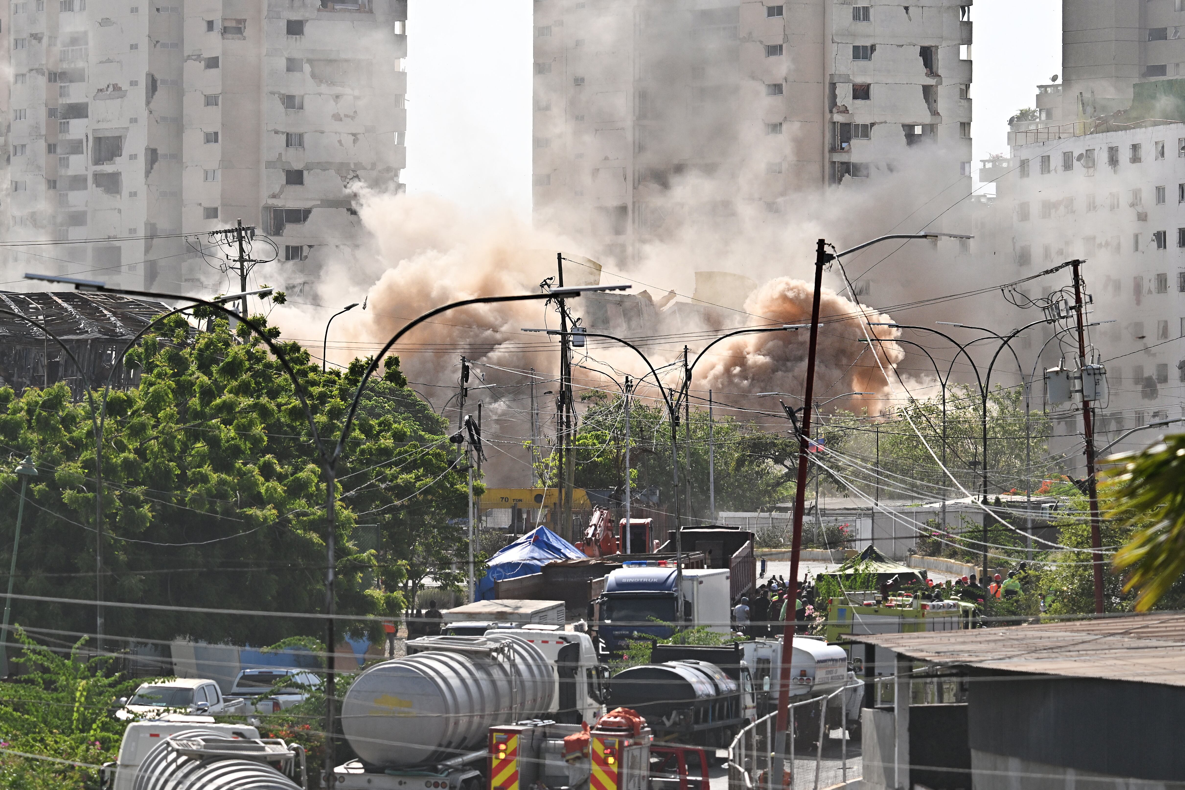 The tower C of the Obras del Poder Popular (OPP) buildings, which was damaged by the June 24 earthquakes, is demolished in Catia La Mar, Venezuela, on July 30, 2026. The UN is preparing a report containing recommendations for the reconstruction of the areas devastated by the two earthquakes that struck Venezuela, which will be presented in 60 days, the organisation�s country coordinator announced on July 29, 2026. (Photo by Juan BARRETO / AFP)