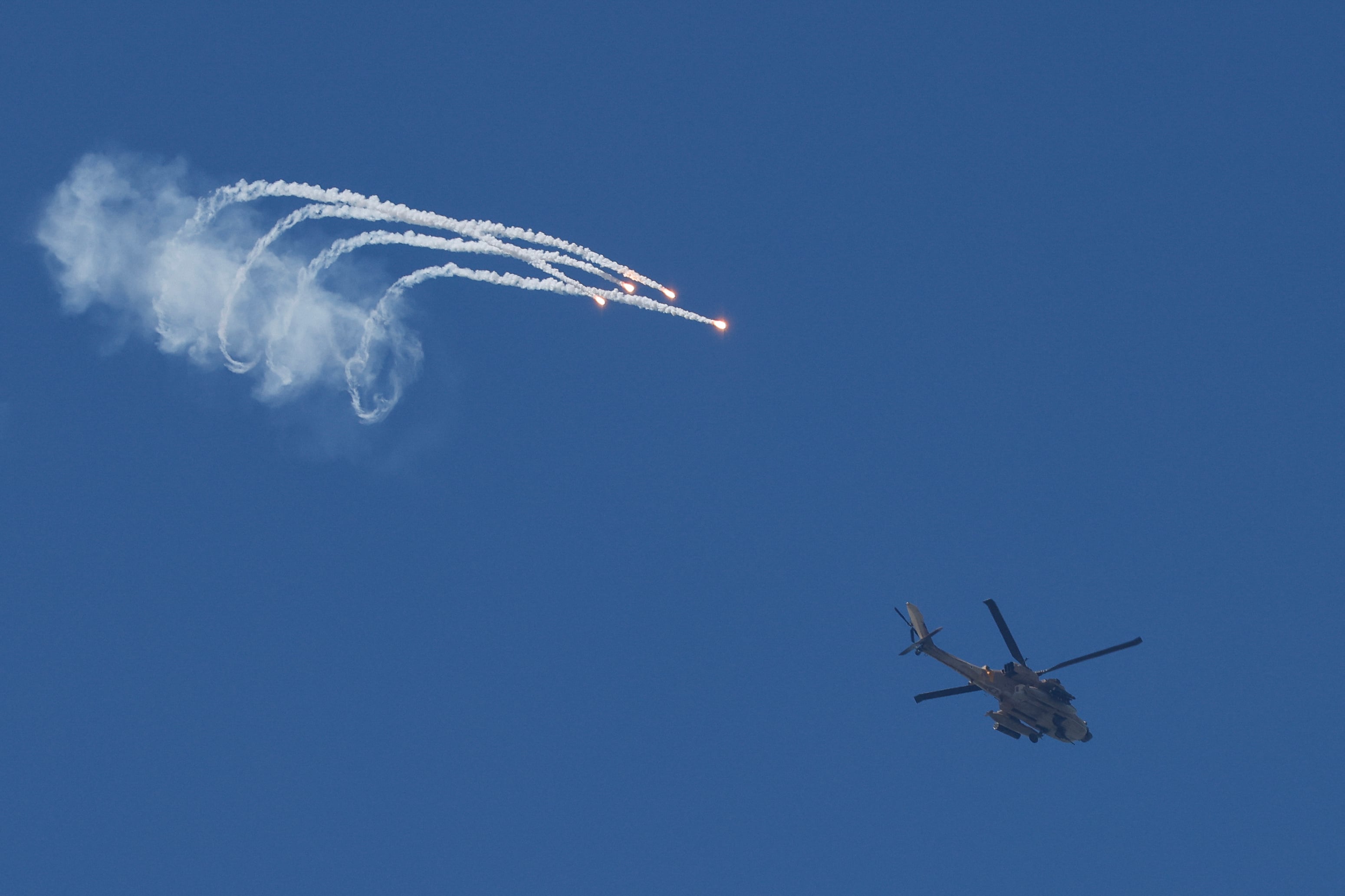 Un helicóptero de ataque AH-64 Apache de la Fuerza Aérea israelí lanza bengalas mientras vuela a lo largo de la frontera entre el norte de Israel y el sur del Líbano, el 12 de abril de 2026.