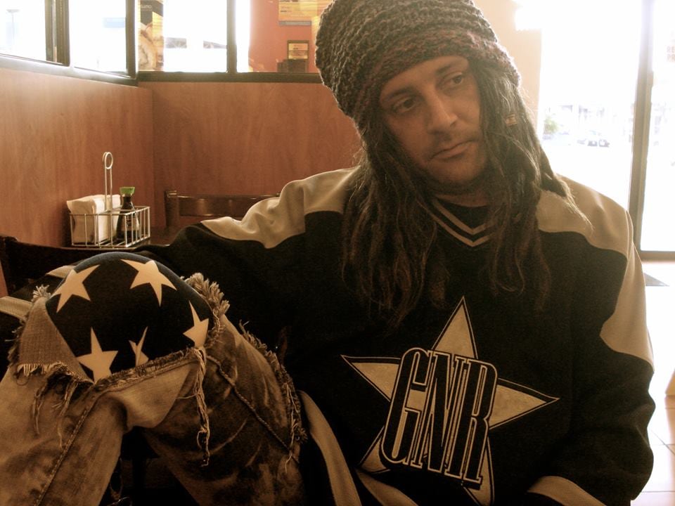 Imagen del expresentador de televisión Luis Lauretto, con un suéter de Guns N'Roses, un gorro y el cabello largo.