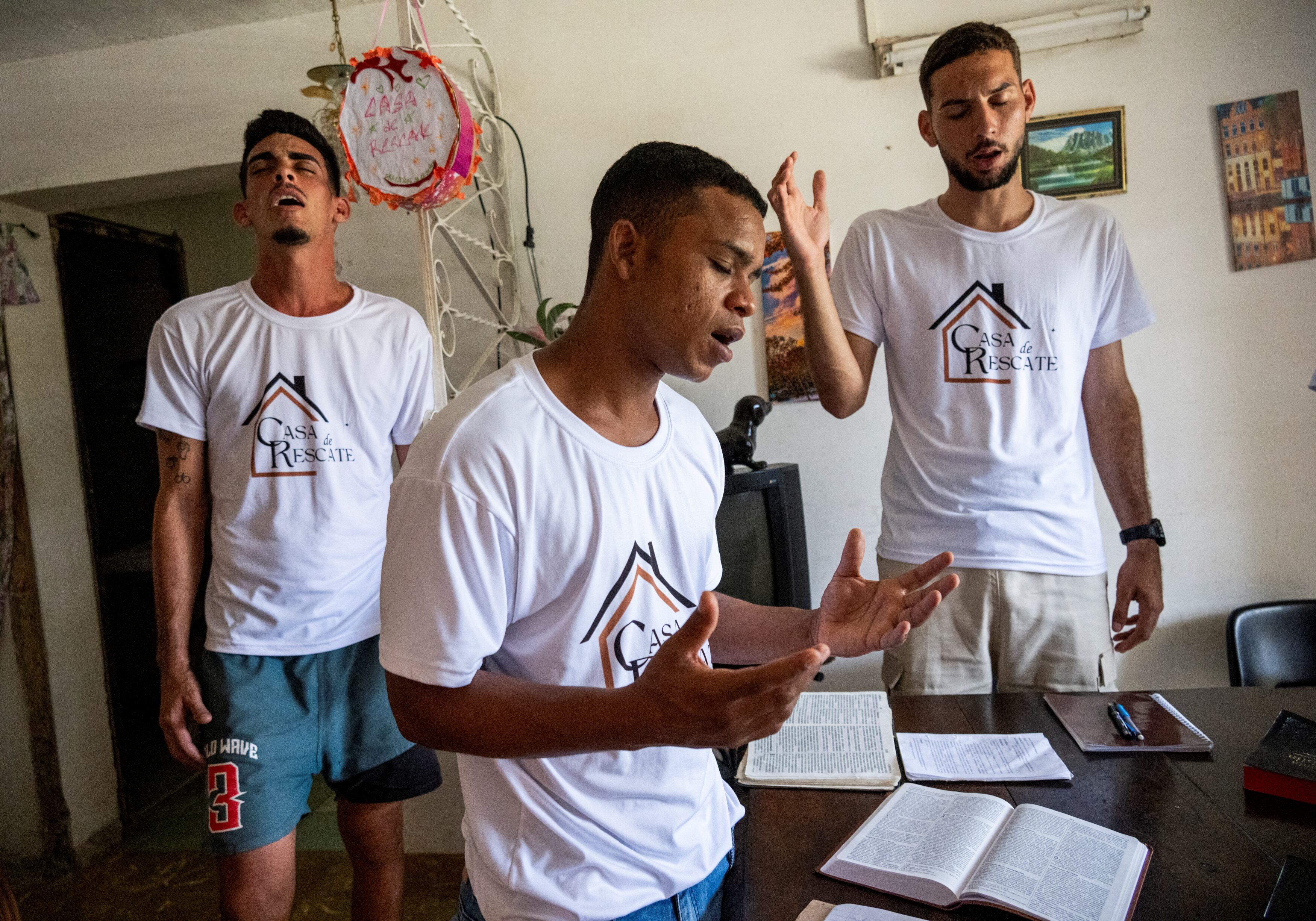 Jovenes en rehabilitación rezan en la Casa del Rescate.