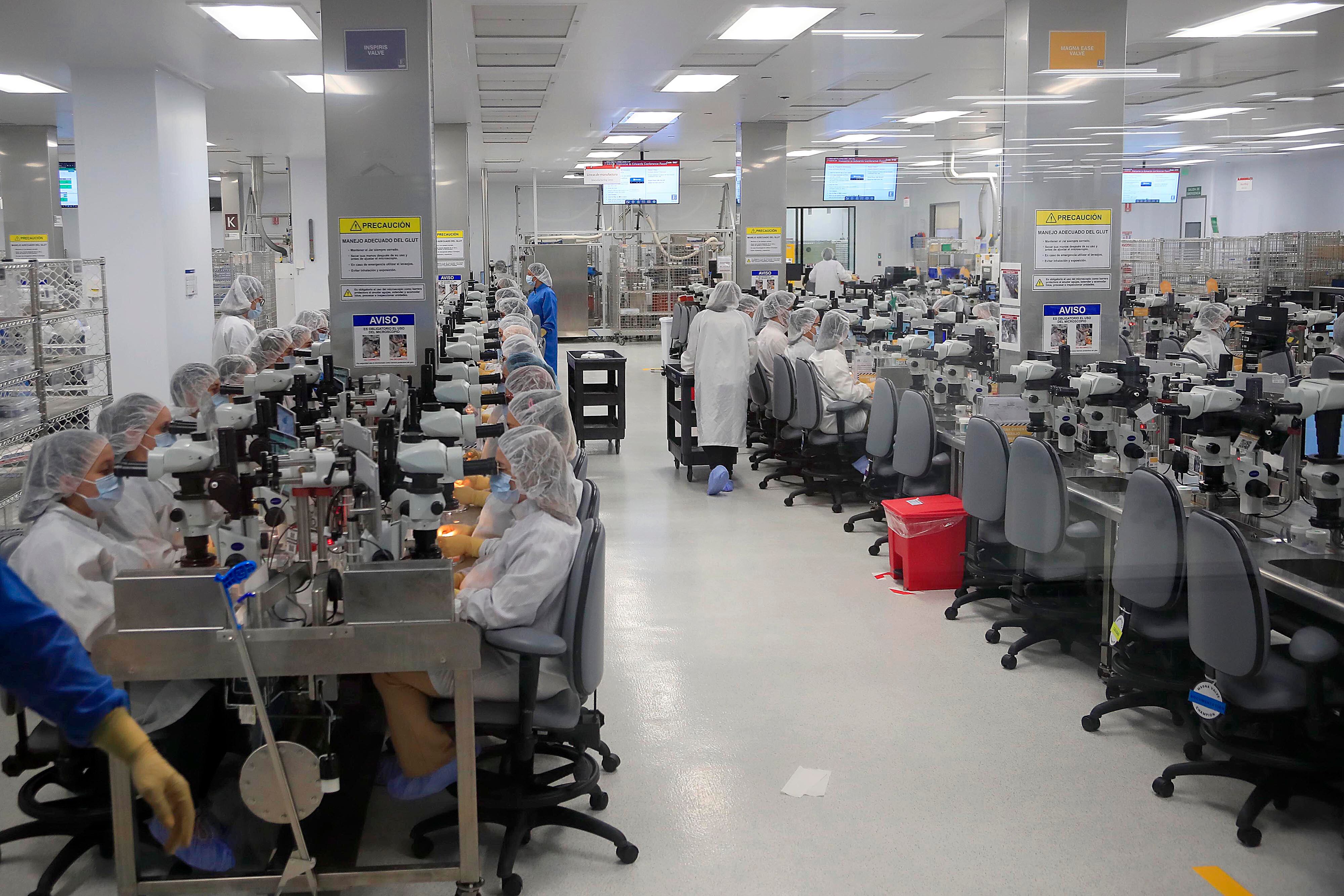 Trabajadores en un ambiente controlado en una empresa de alta tecnología dentro de una zona franca en Costa Rica, beneficiados por exoneraciones fiscales como IVA y renta.