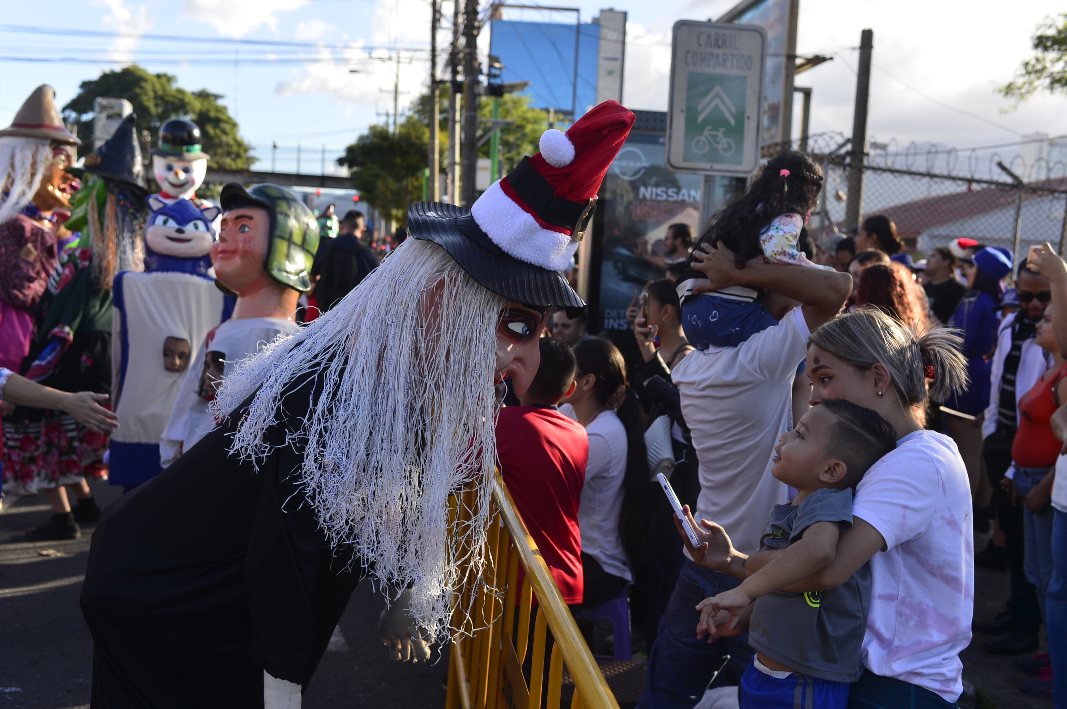 Imágenes de artistas, músicos de bandas, bailarines folclóricos y mascaradas que participaron en el pasacalles previo al Festival de la Luz 2024 en San José.