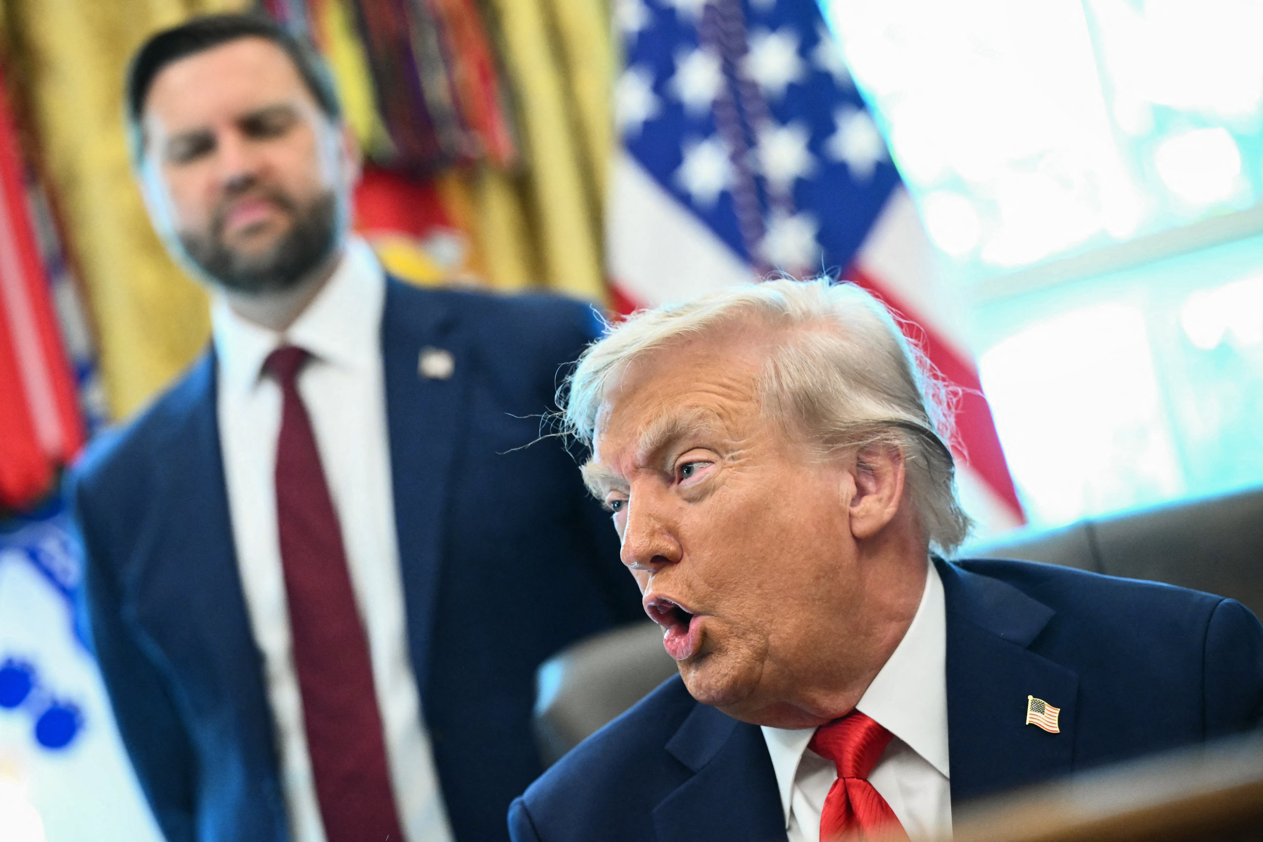 (L/R) Vice President JD Vance looks on as US President Donald Trump speaks to the press after signing an executive order that aims to end cashless bail, in the Oval Office of the White House in Washington, DC on August 25, 2025. (Photo by Mandel NGAN / AFP)