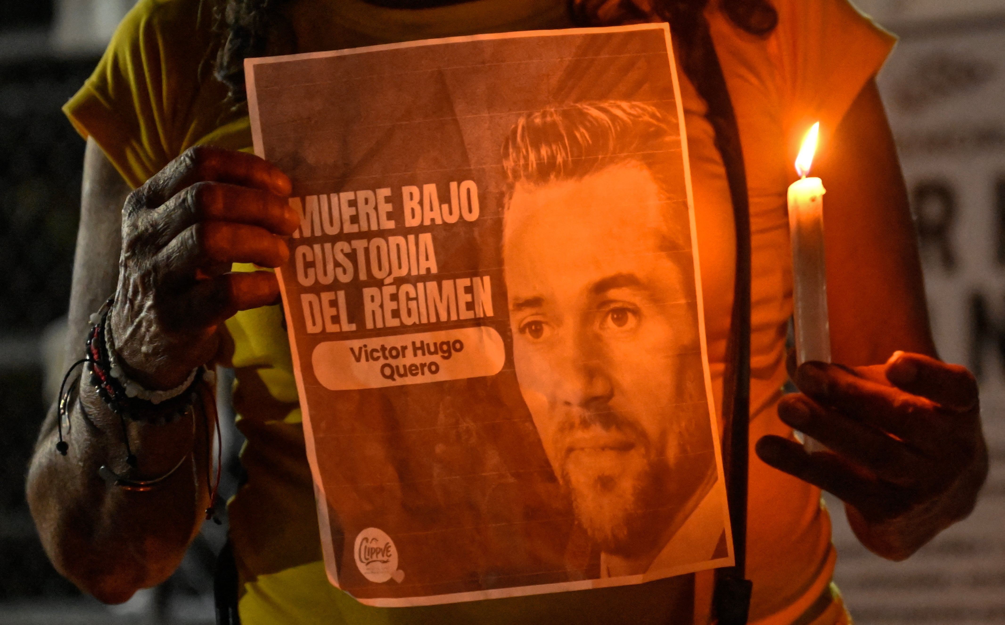 Una mujer sostiene un cartel con la imagen del difunto preso político venezolano Víctor Hugo Quero Navas. (Foto de Juan BARRETO / AFP)