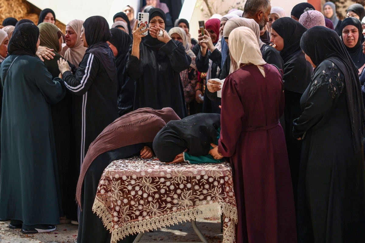 Familiares del palestino Khalil Rasem Khalil Shahada, de 16 años, lloran durante su funeral y el de Omar Mohammad Naji al-Nassan, de 19 años, en la aldea de Al-Mughayyir, al este de Ramala, en la Cisjordania ocupada por Israel.