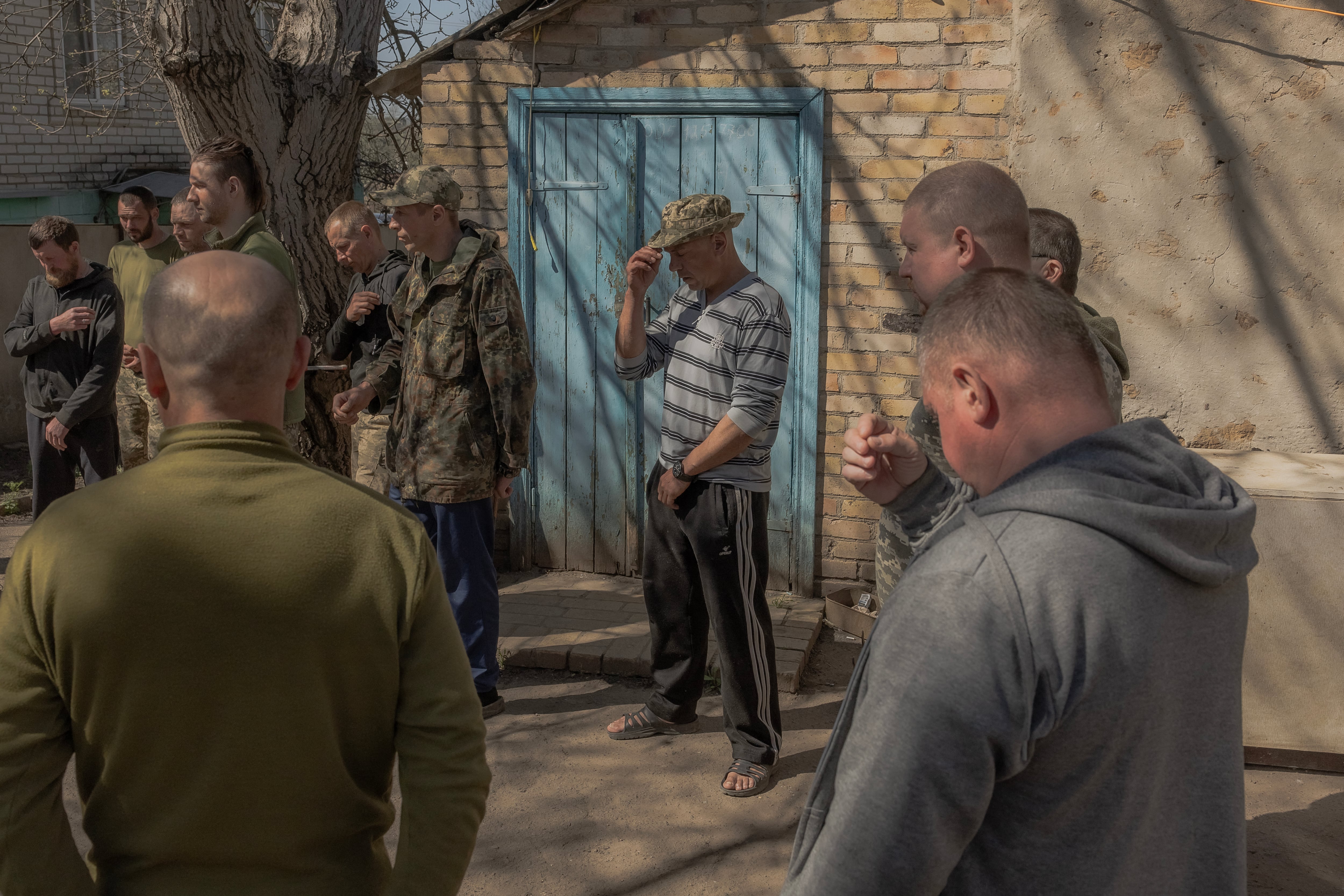 Ukrainian servicemen of the 100th brigade cross themselves during a service by a military chaplain to celebrate Orthodox Easter, in the Donetsk region, on April 20, 2025, amid the Russian invasion of Ukraine. Ukraine's President Volodymyr Zelensky said Russian forces were continuing their shelling and assaults along the front line despite Russian President Vladimir Putin announcing a surprise but brief Easter truce. (Photo by Roman PILIPEY / AFP)