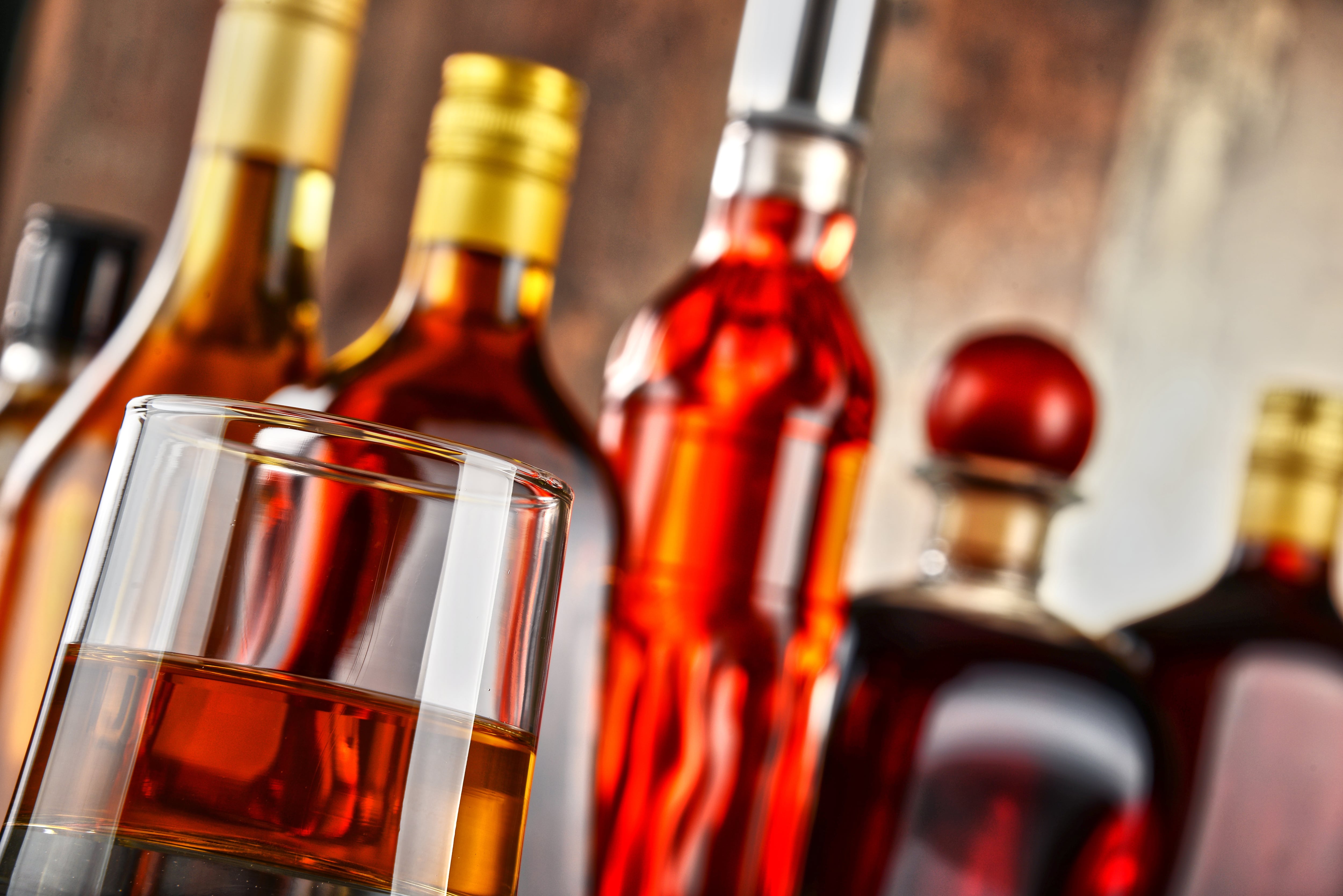 Bebidas alcohólicas en botellas y copas representan el impuesto selectivo de consumo en Costa Rica, cuestionado por Estados Unidos por afectar importaciones según el contenido de alcohol.