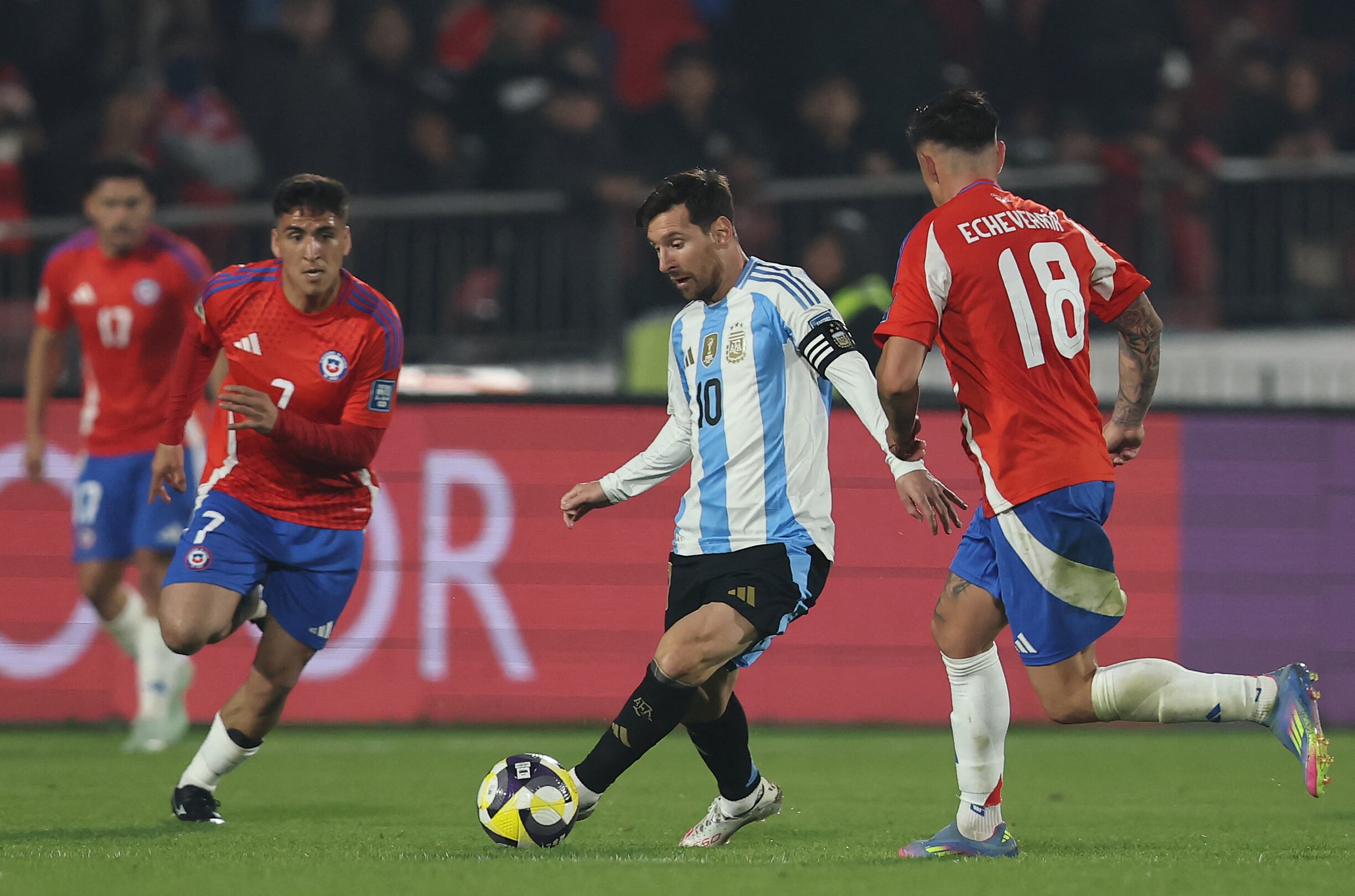El argentino Lionel Messi controla el balón junto a los chilenos Marcelino Núñez (18) y Rodrigo Echeverría, durante el partido por las eliminatorias mundialistas.