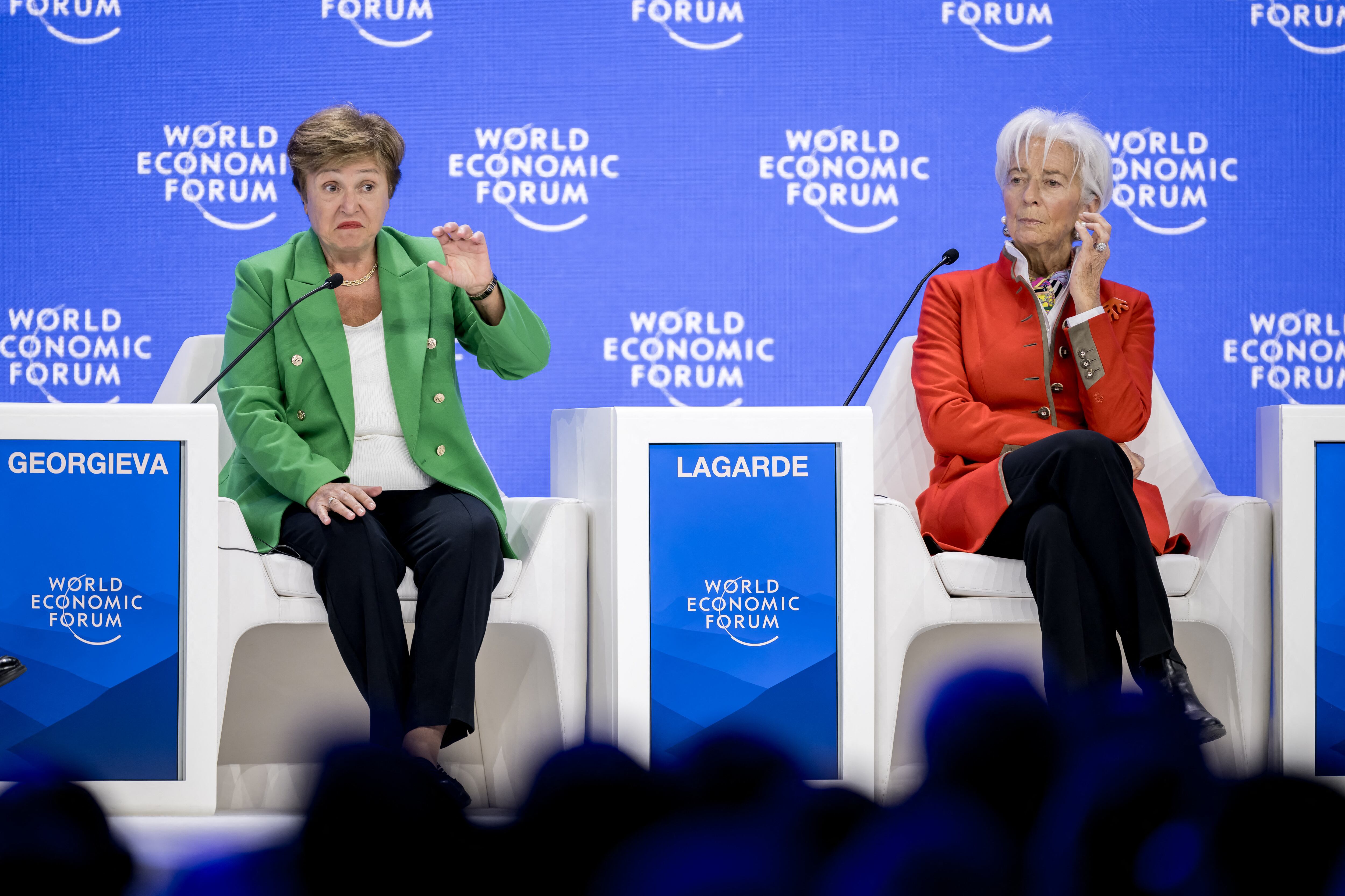 Kristalina Georgieva, directora gerente del FMI, y Christine Lagarde, presidenta del BCE, sentadas en un panel durante el Foro Económico Mundial en Davos, con letreros identificativos y fondo azul del evento.