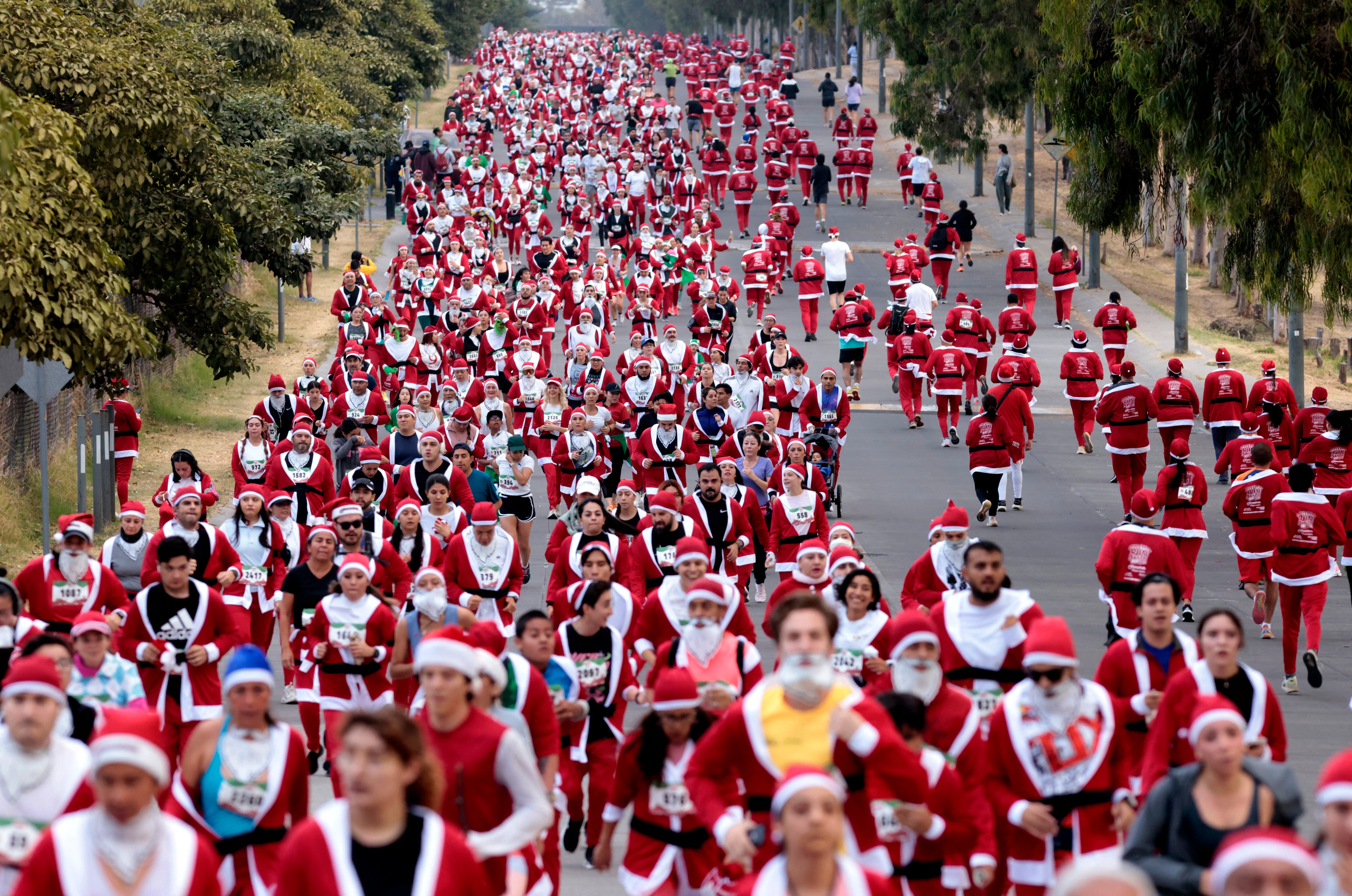Corredores vestidos de Papá Noel y elfos participan en la carrera navideña anual 'Run Santa Run' en Zapopan, Jalisco, México, el 8 de diciembre de 2024.