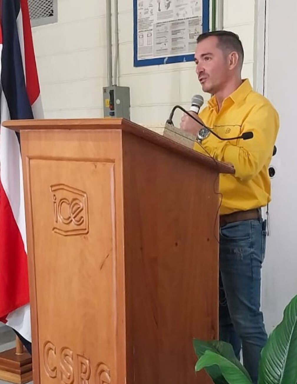 El periodista José Ernesto Herrera en un podio hablando al micrófono.
