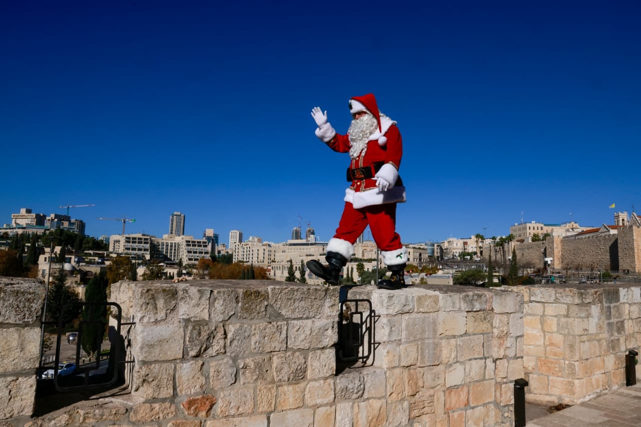 Issa Kassissieh, un palestino vestido como Santa Claus, posa para una foto en la Puerta de Jaffa de la Ciudad Vieja de Jerusalén el 19 de diciembre de 2024, en vísperas de la Navidad.
