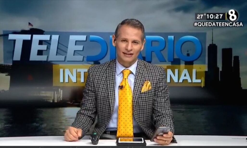 Imagen del periodista Alejandro Ramírez, presentando el 'Telediario Internacional', usa un traje de color gris y una corbata amarilla.