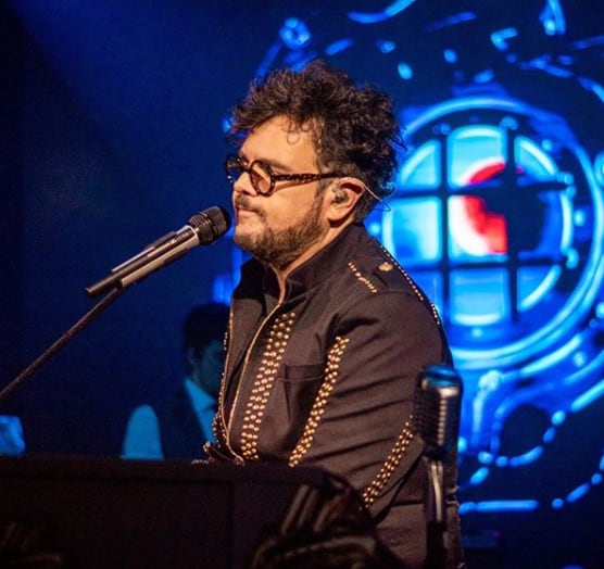 Aleks Syntek tocando el piano en concierto.