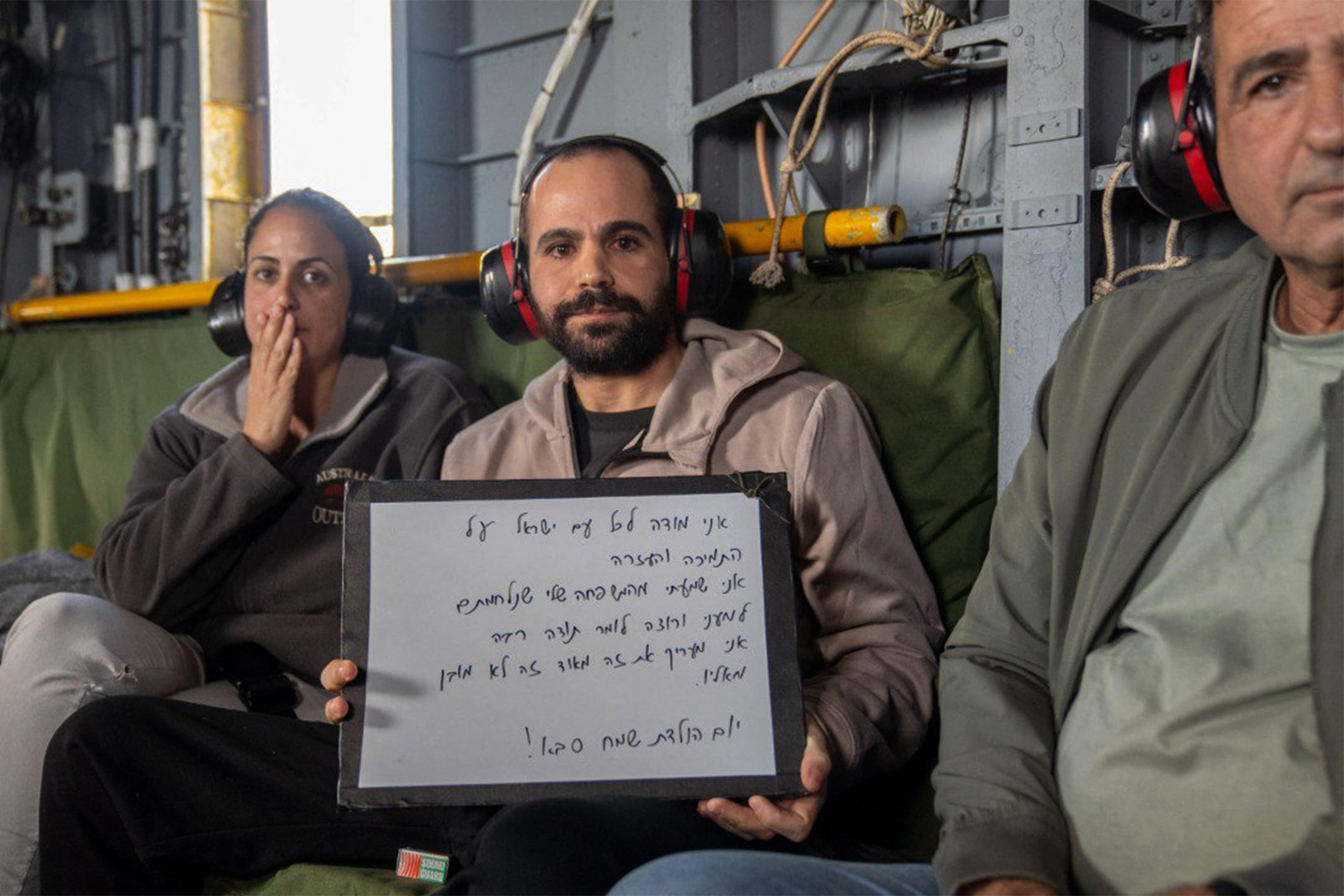 Esta fotografía difundida por la oficina de prensa del gobierno israelí (GPO) muestra al rehén recién liberado Yarden Bibas (centro) junto con su hermana y su padre a bordo de un helicóptero militar camino del hospital Sheba en Ramat Gan.