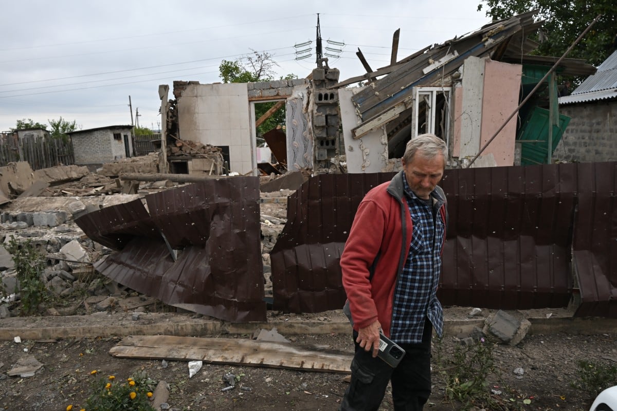 Un residente junto a la vivienda destruida de su madre, de 80 años, quien resultó herida en lo que autoridades locales instaladas por Rusia calificaron como un ataque con drones ucranianos, en Zolotaryovka, en Donetsk, Ucrania, bajo control ruso.