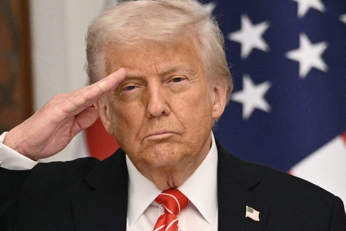 US President Donald Trump salutes during the playing of the US national anthem ahead of a state dinner at the Lusail Palace in Doha on May 14, 2025. (Photo by Brendan SMIALOWSKI / AFP)