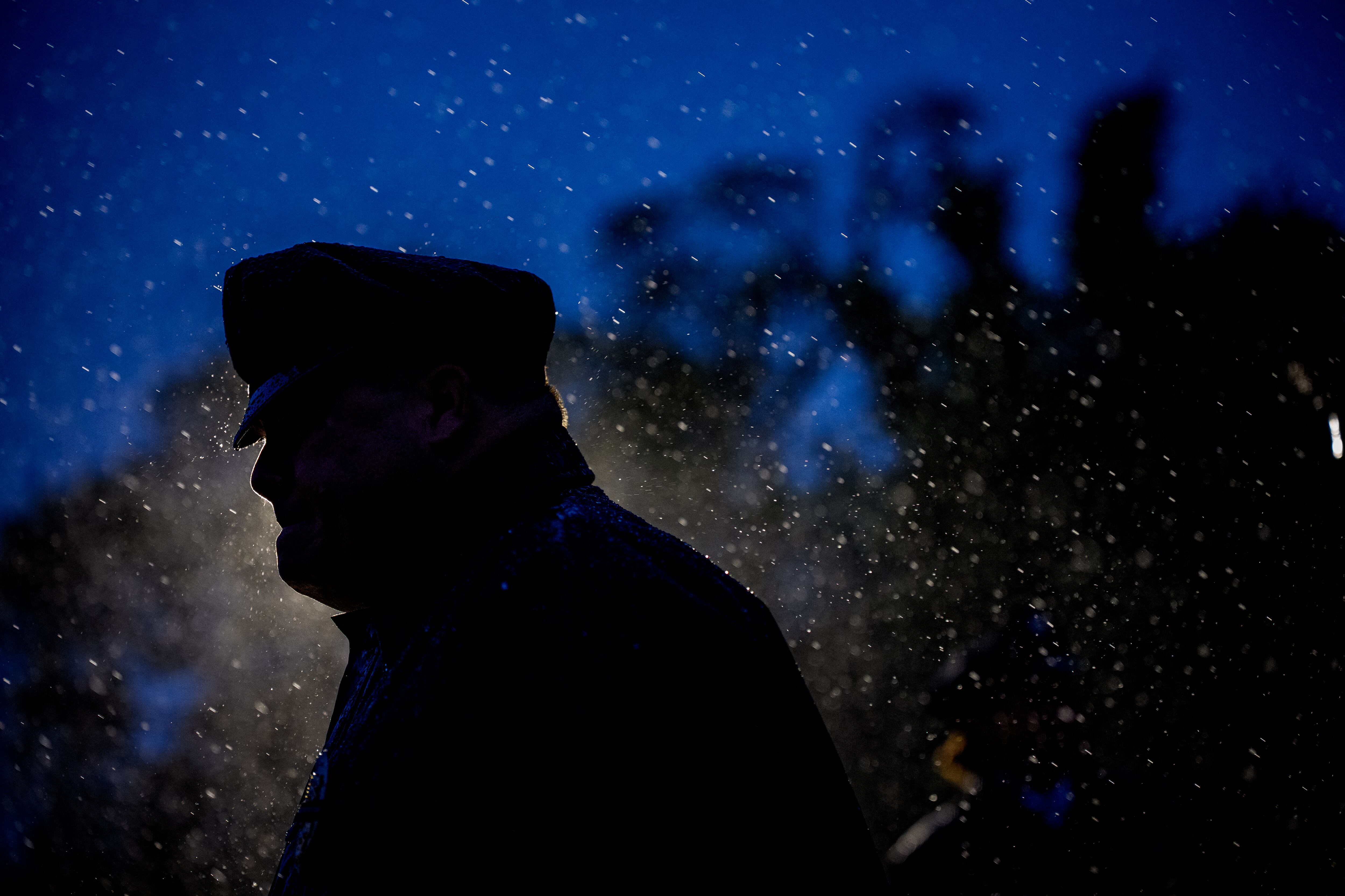 WASHINGTON, DC - MAY 13: A police officer joins thousands of law enforcement officers and their family and supporters in a driving rain for the National Police Week 37th annual candlelight vigil on the National Mall on May 13, 2025 in Washington, DC. Police, political leaders and family members of those officers who died in the line of duty gathered on the National Mall to remember and honor them. Andrew Harnik/Getty Images/AFP (Photo by Andrew Harnik / GETTY IMAGES NORTH AMERICA / Getty Images via AFP)